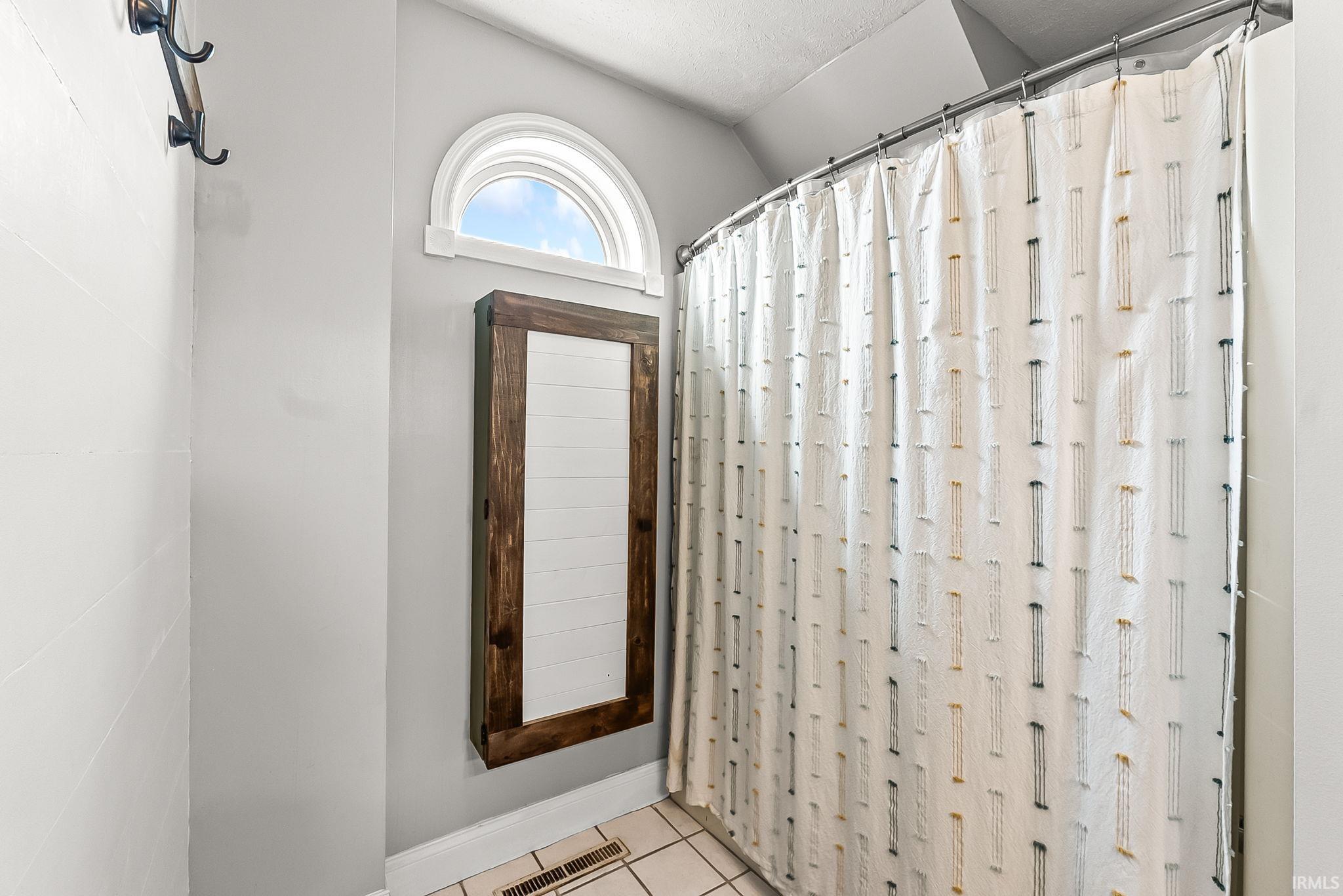 Arched transom window above a wood-framed built-in cabinet