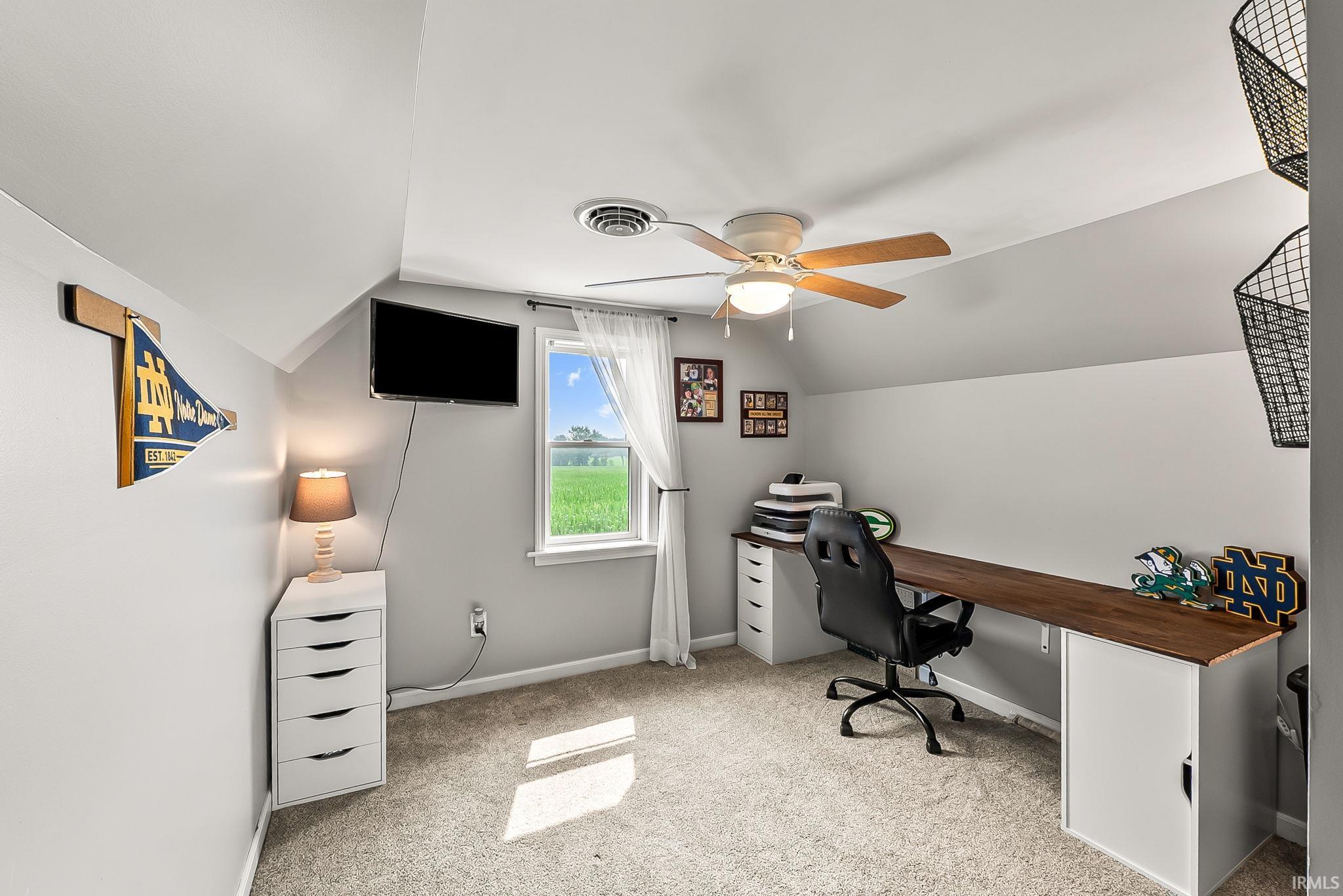 Attic room featuring sloped ceilings, a ceiling fan with integrated lighting, and carpeted flooring