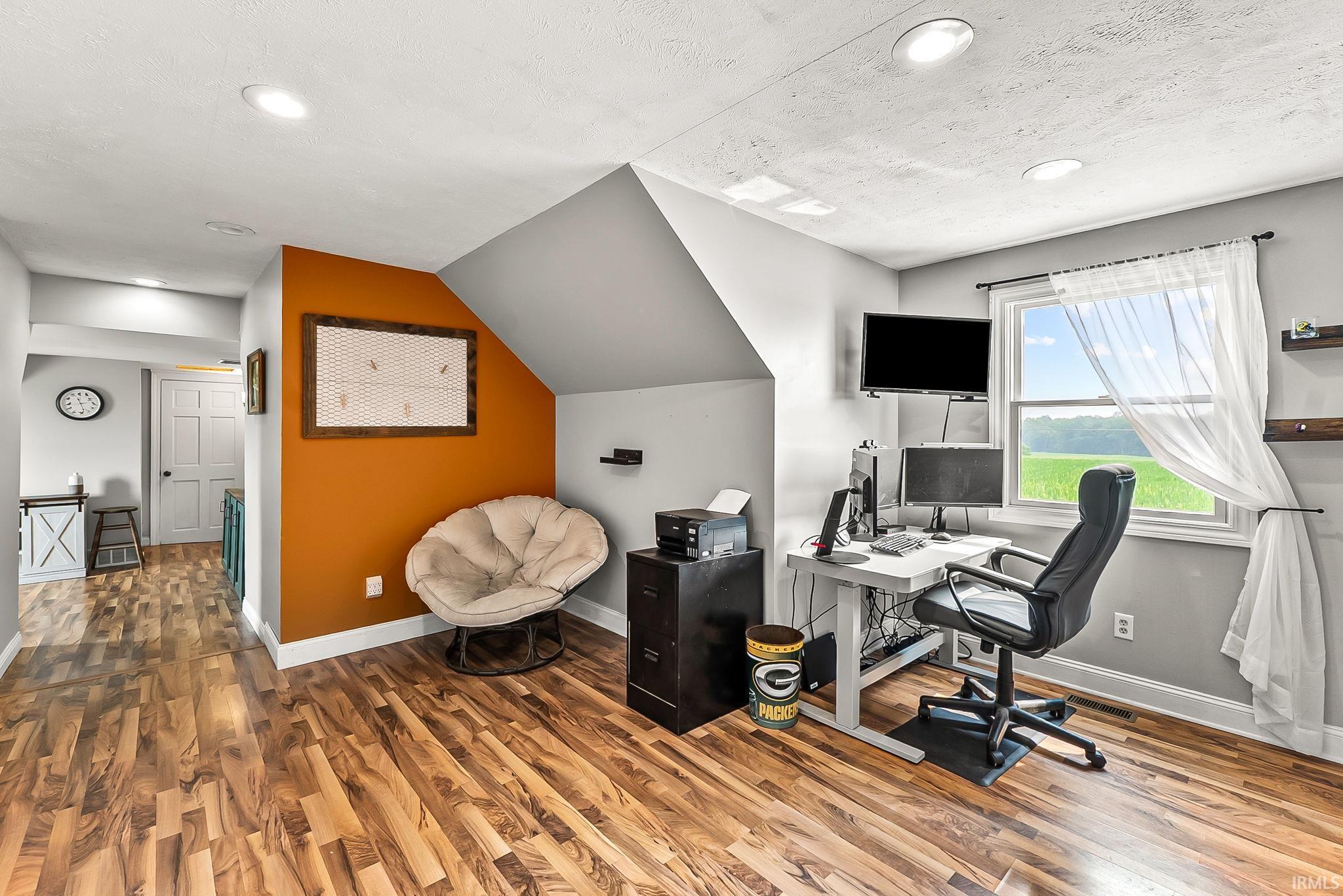 Versatile bonus room featuring wood-finish flooring, recessed lighting, and a window providing natural light
