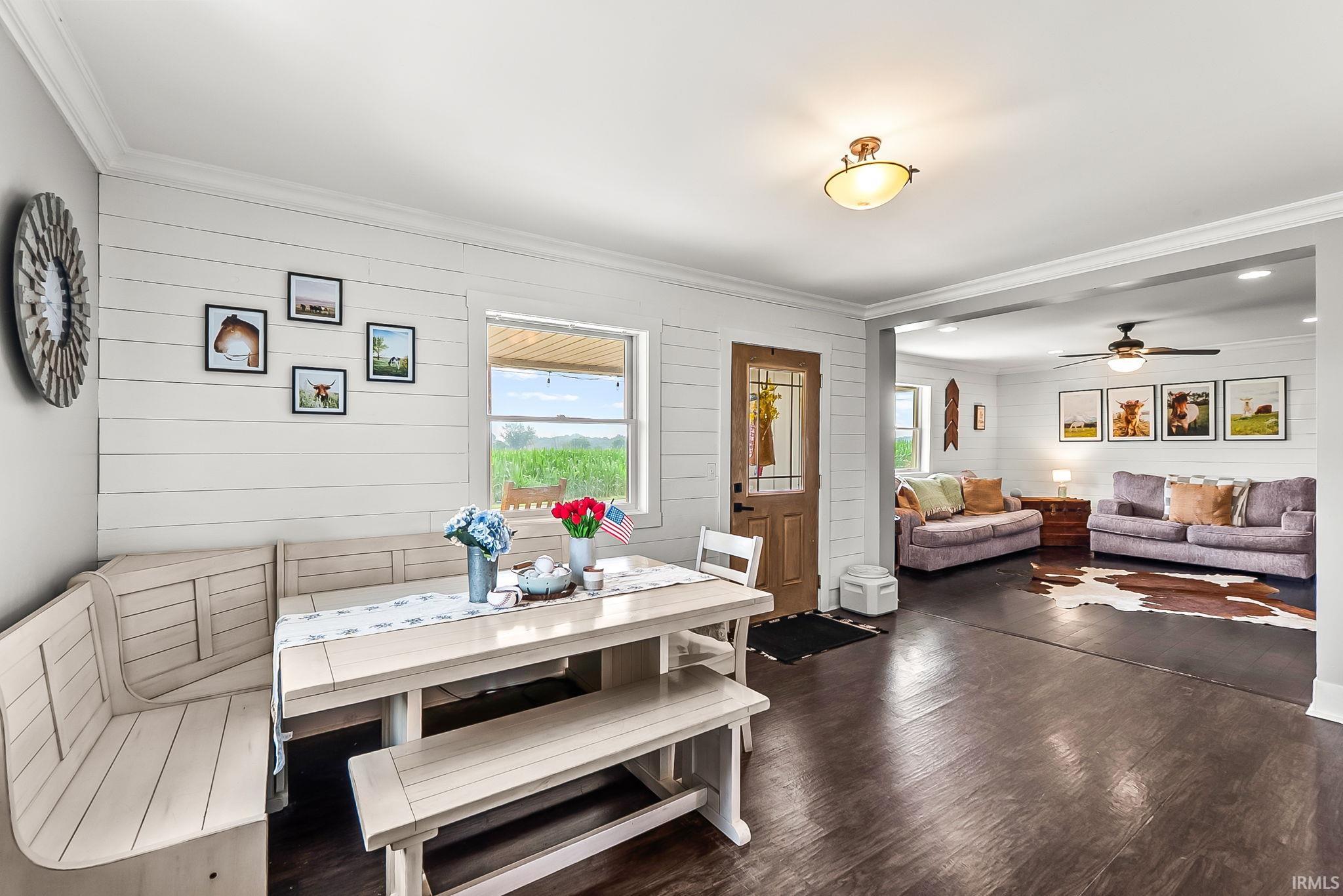 Open-concept interior featuring wood-finish flooring, shiplap wall accents, and crisp white trim