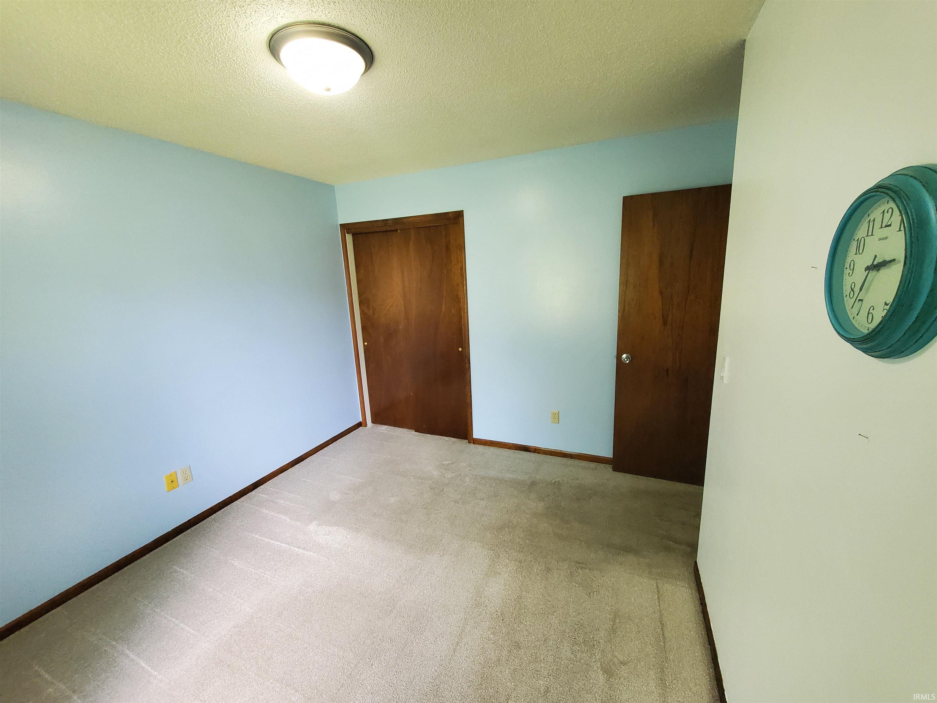 Neutral tone wall-to-wall carpeting complements the light blue wall paint