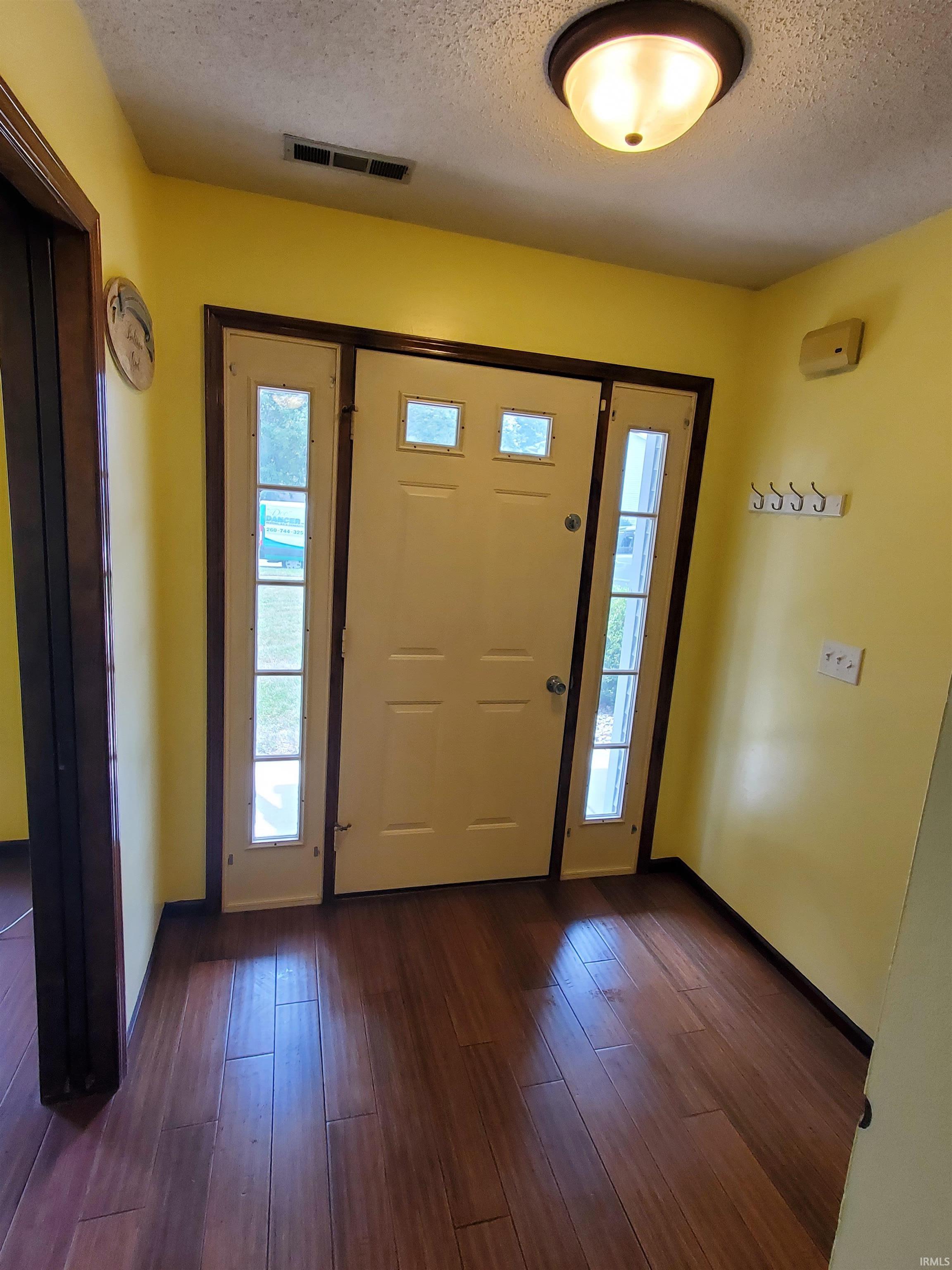 Entryway featuring a panel door with multiple lites, framed by sidelight windows and an overhead transom