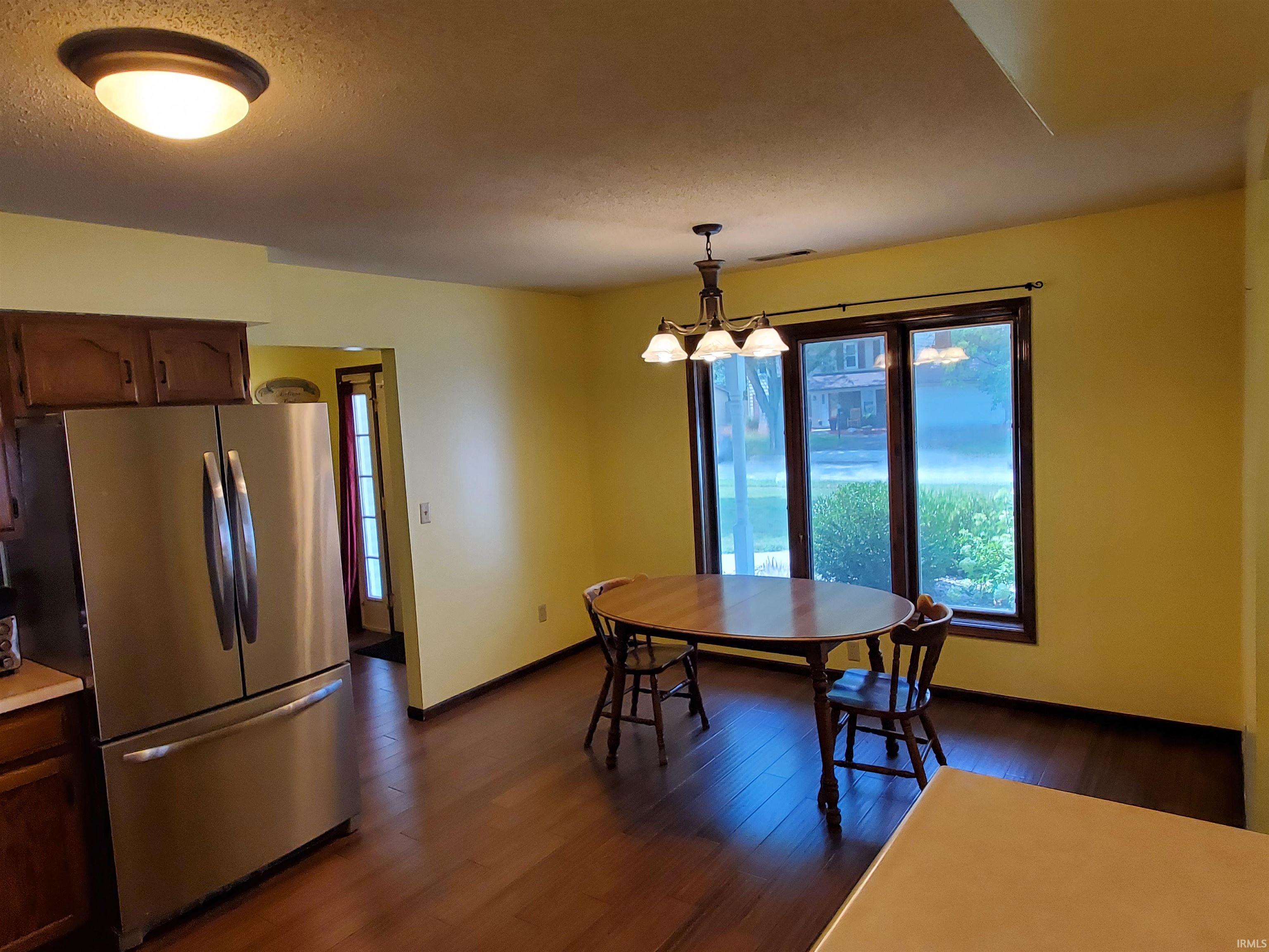Dining area featuring wood-finish flooring and a multi-pane window with dark trim