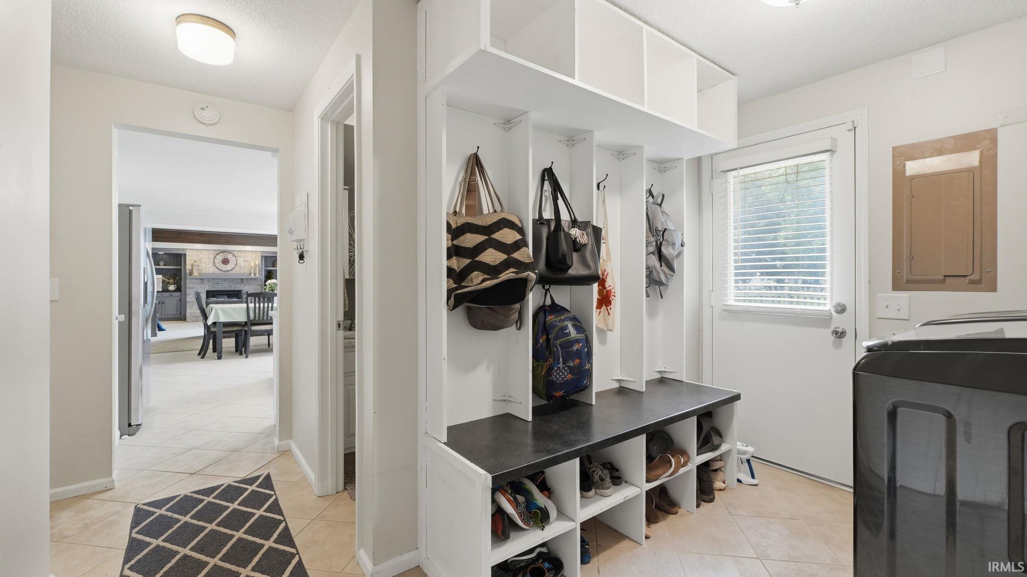 Mudroom featuring built-in white cabinetry with individual cubbies, hooks, and shoe storage