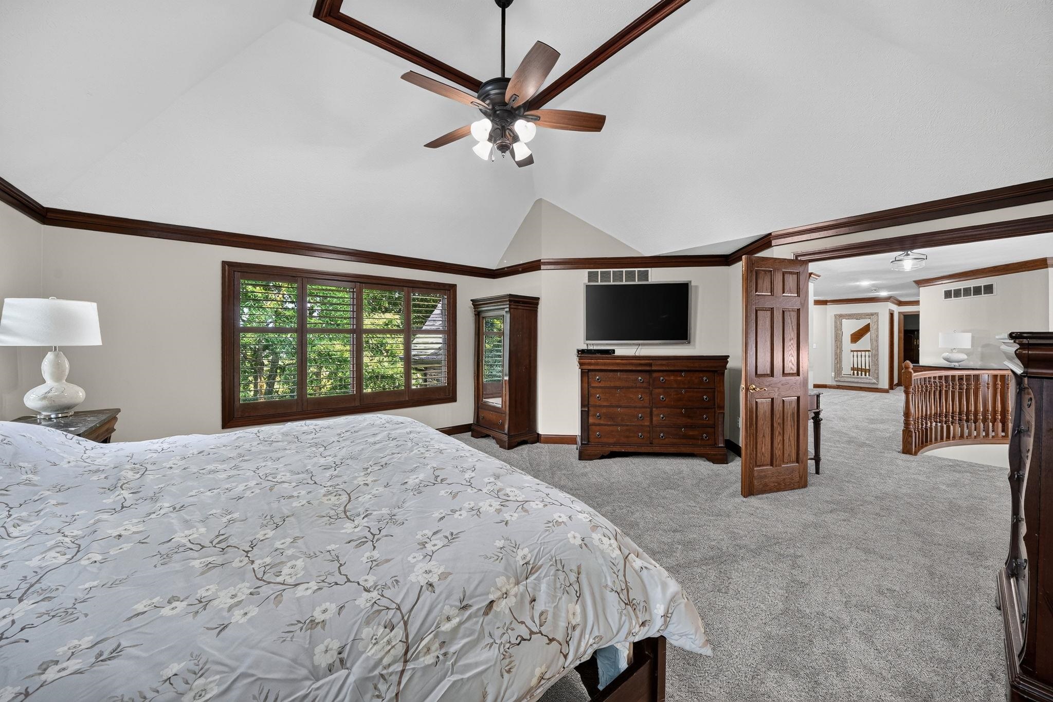 Vaulted ceiling with wood-finish beams, ceiling fan, and recessed lighting