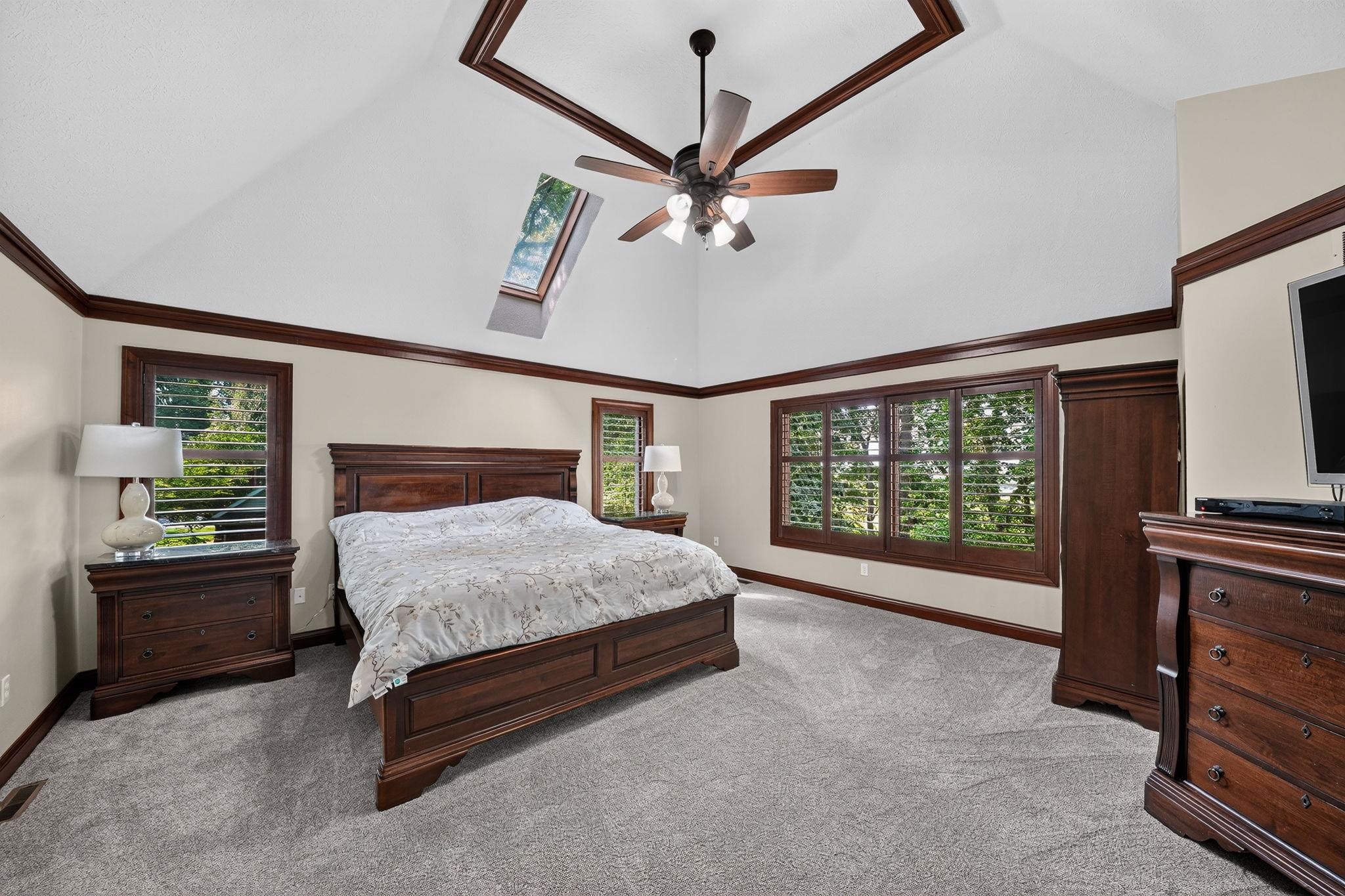 Vaulted ceilings with a coffered detail and skylight define this bedroom