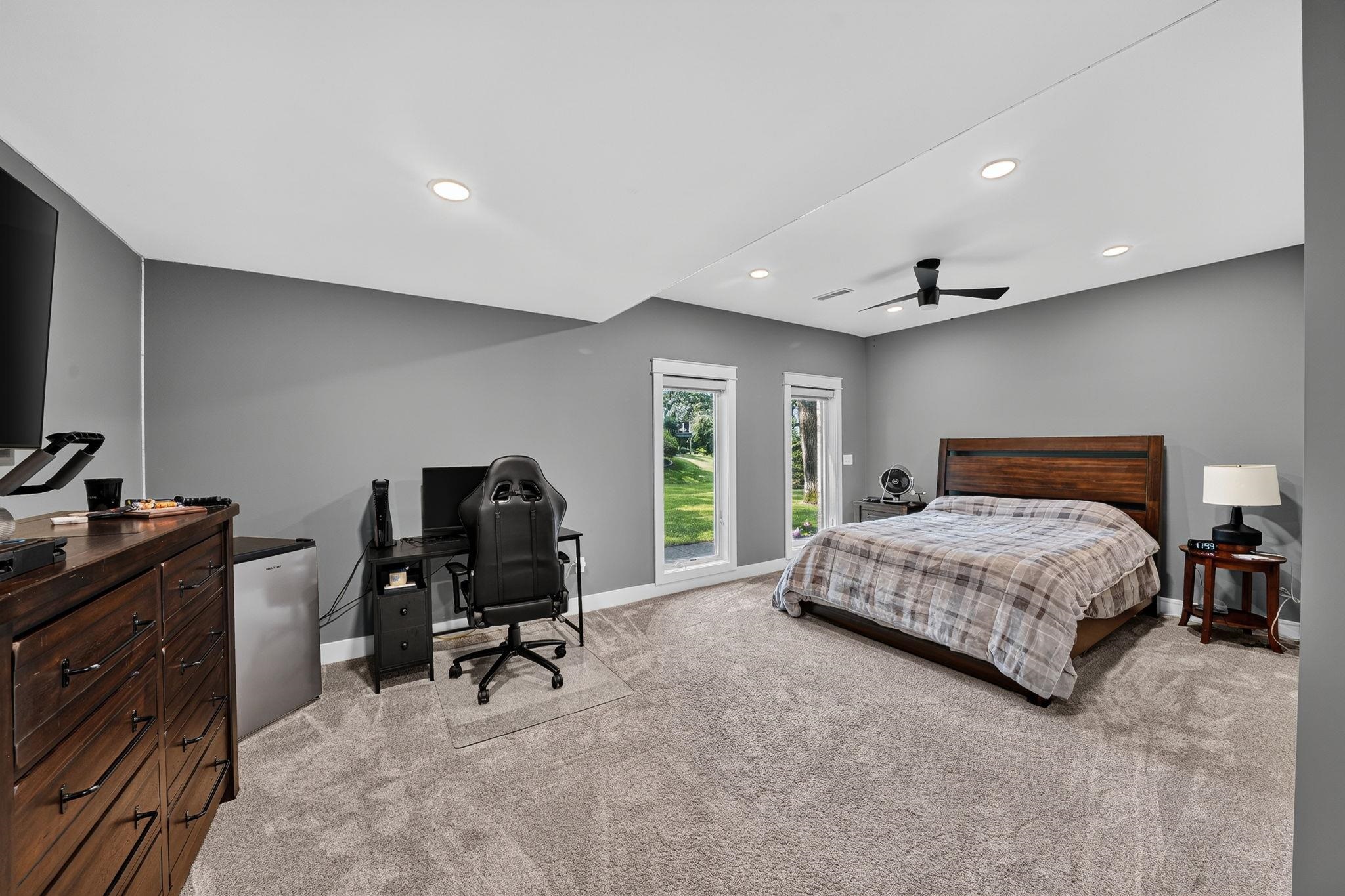 Spacious room featuring neutral gray walls, recessed lighting, and soft gray carpeting