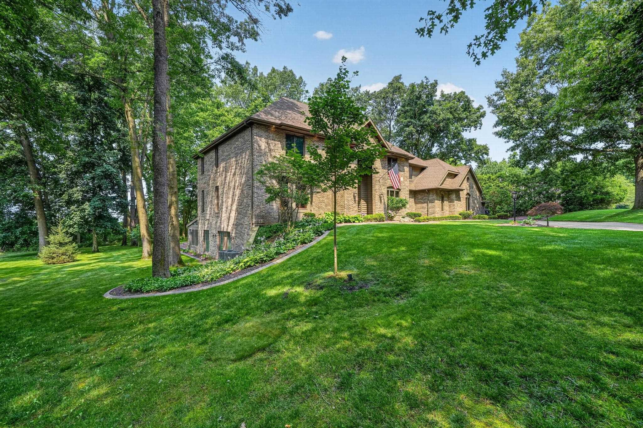 Brick exterior residence featuring multiple gables and a hip roofline