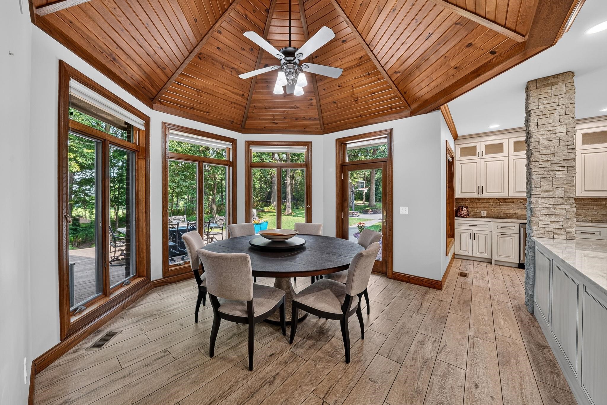 Dining area with a striking wooden plank ceiling and a central ceiling fan