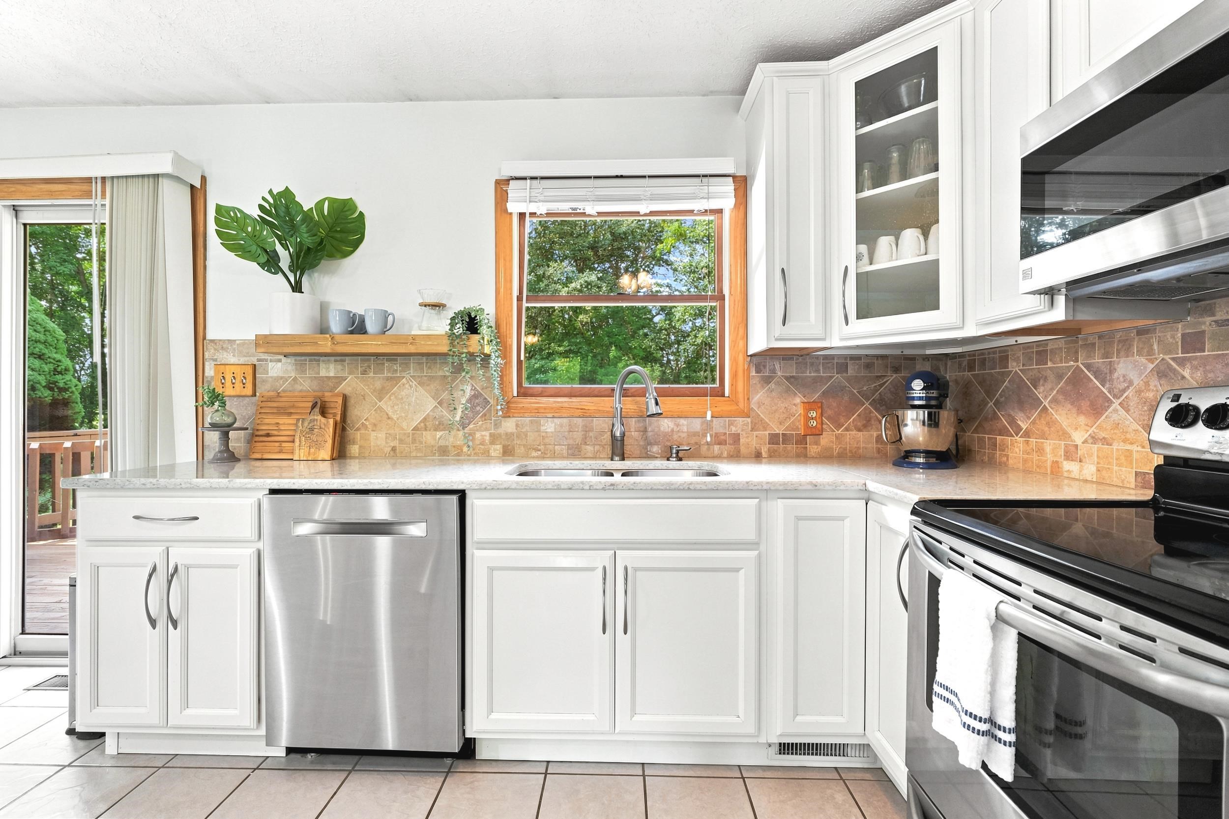 Kitchen featuring white cabinetry, stainless steel appliances, and a light-toned countertop