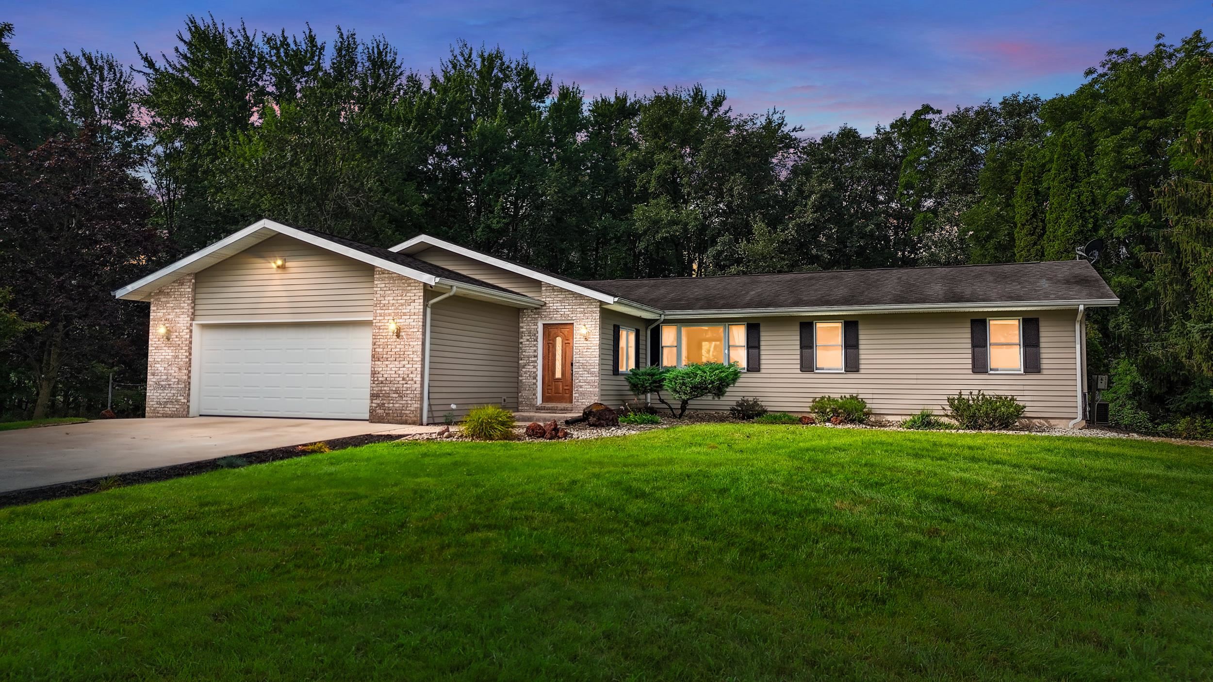 Ranch-style residence featuring a brick facade accent, horizontal siding, and a two-car garage