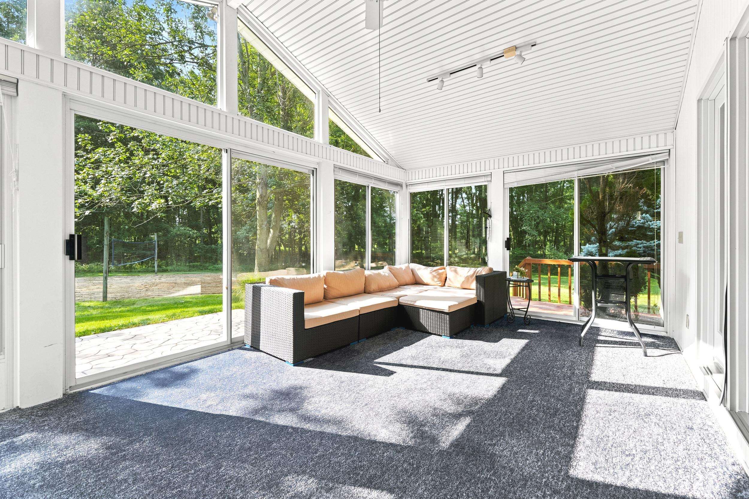 Sunroom with vaulted ceilings and extensive glass panels