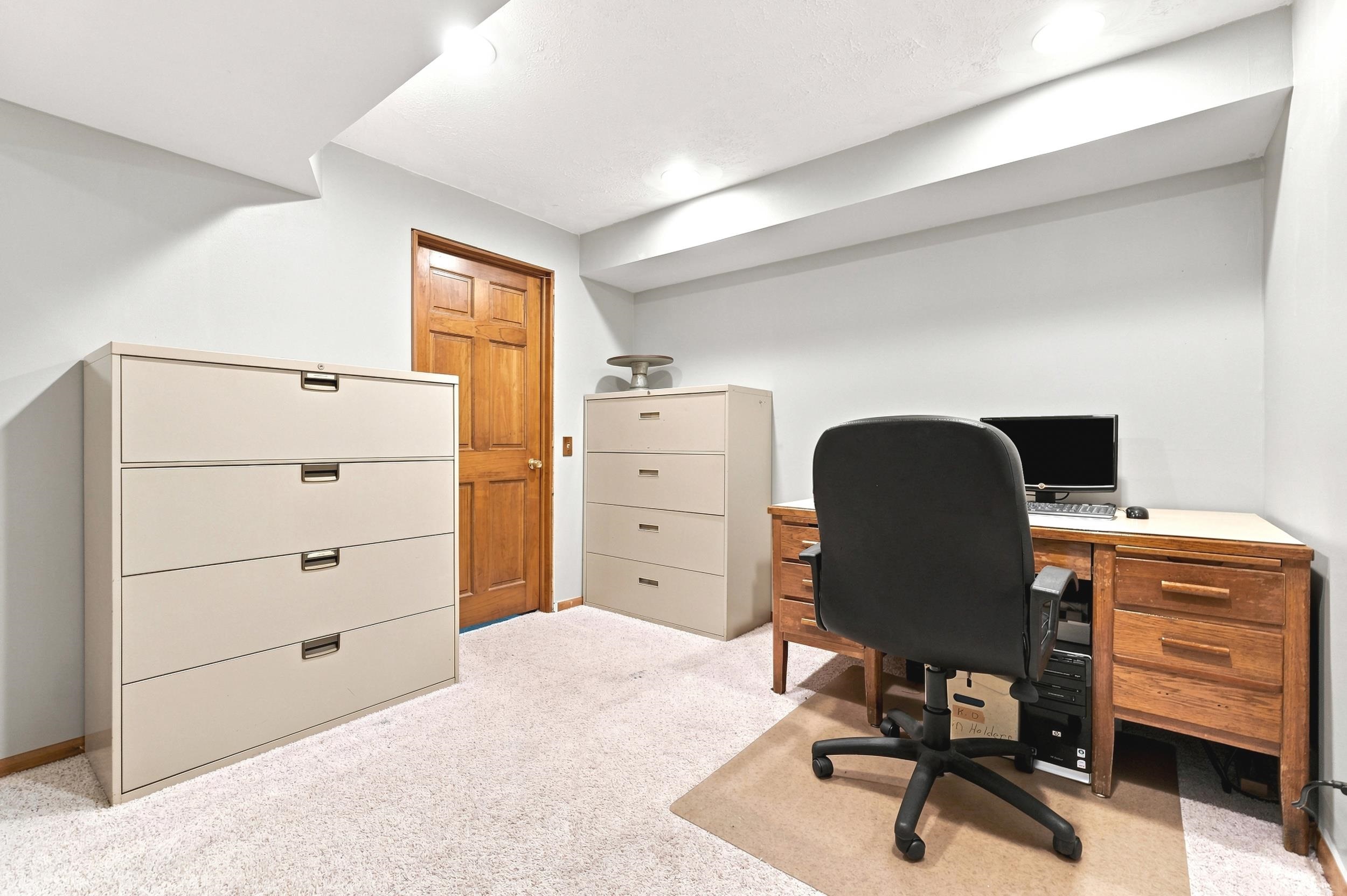 Carpeted room featuring a solid wood door, light gray wall paint, and recessed ceiling lighting