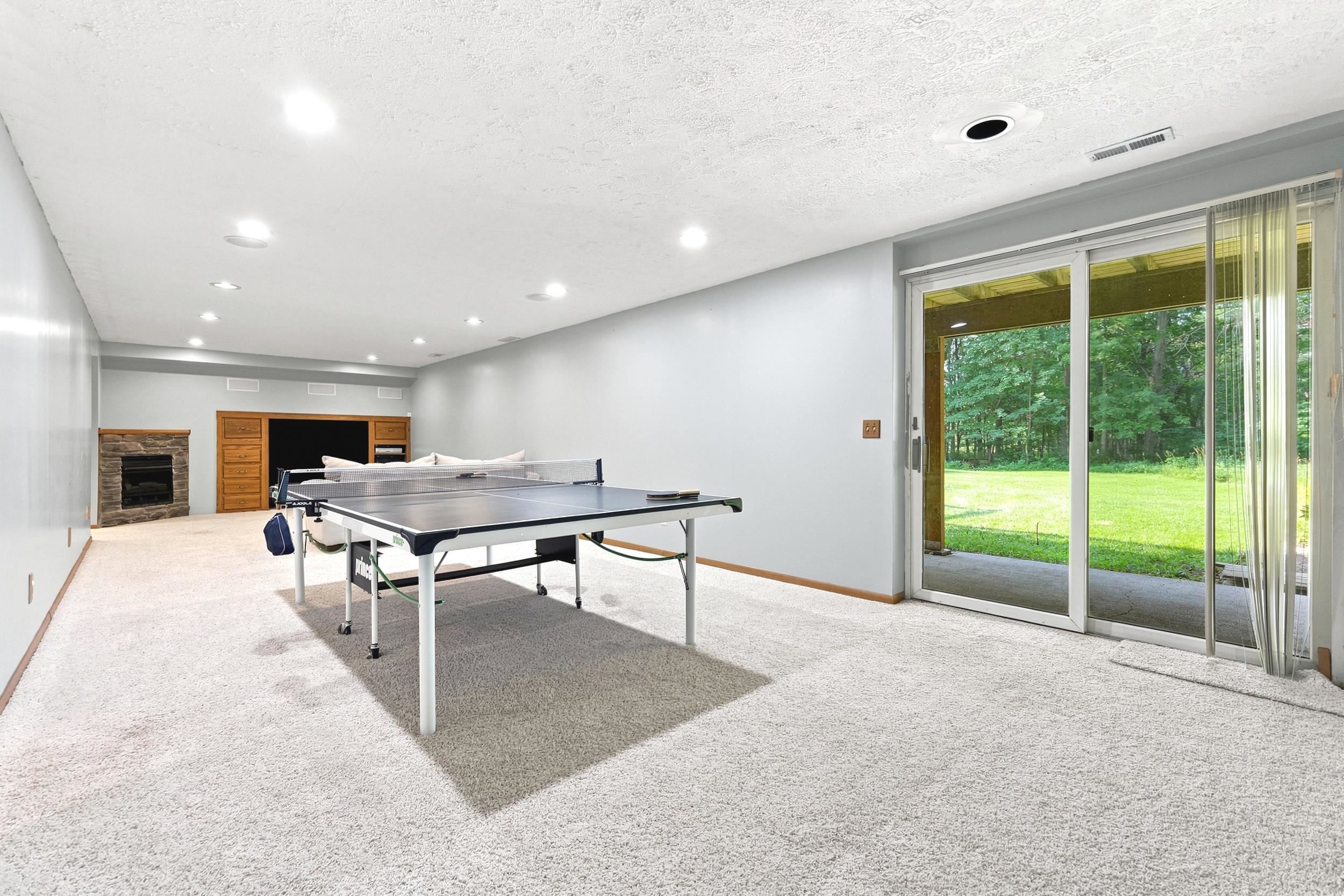 Spacious lower-level room featuring light gray wall paint and recessed ceiling lighting