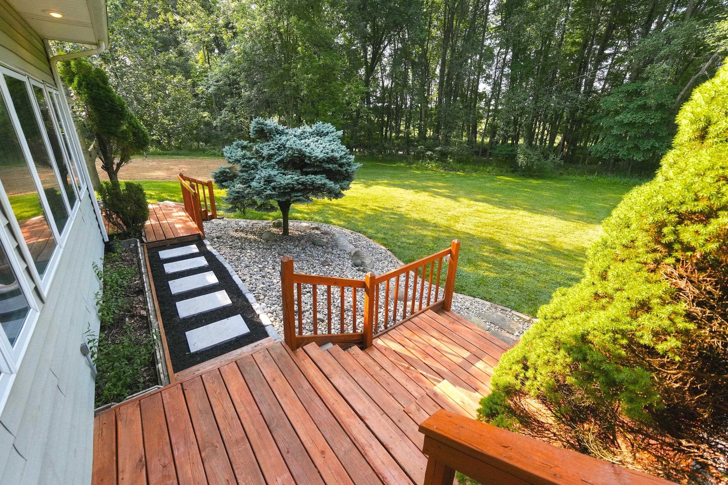 Expansive outdoor deck with natural wood railing and stairs