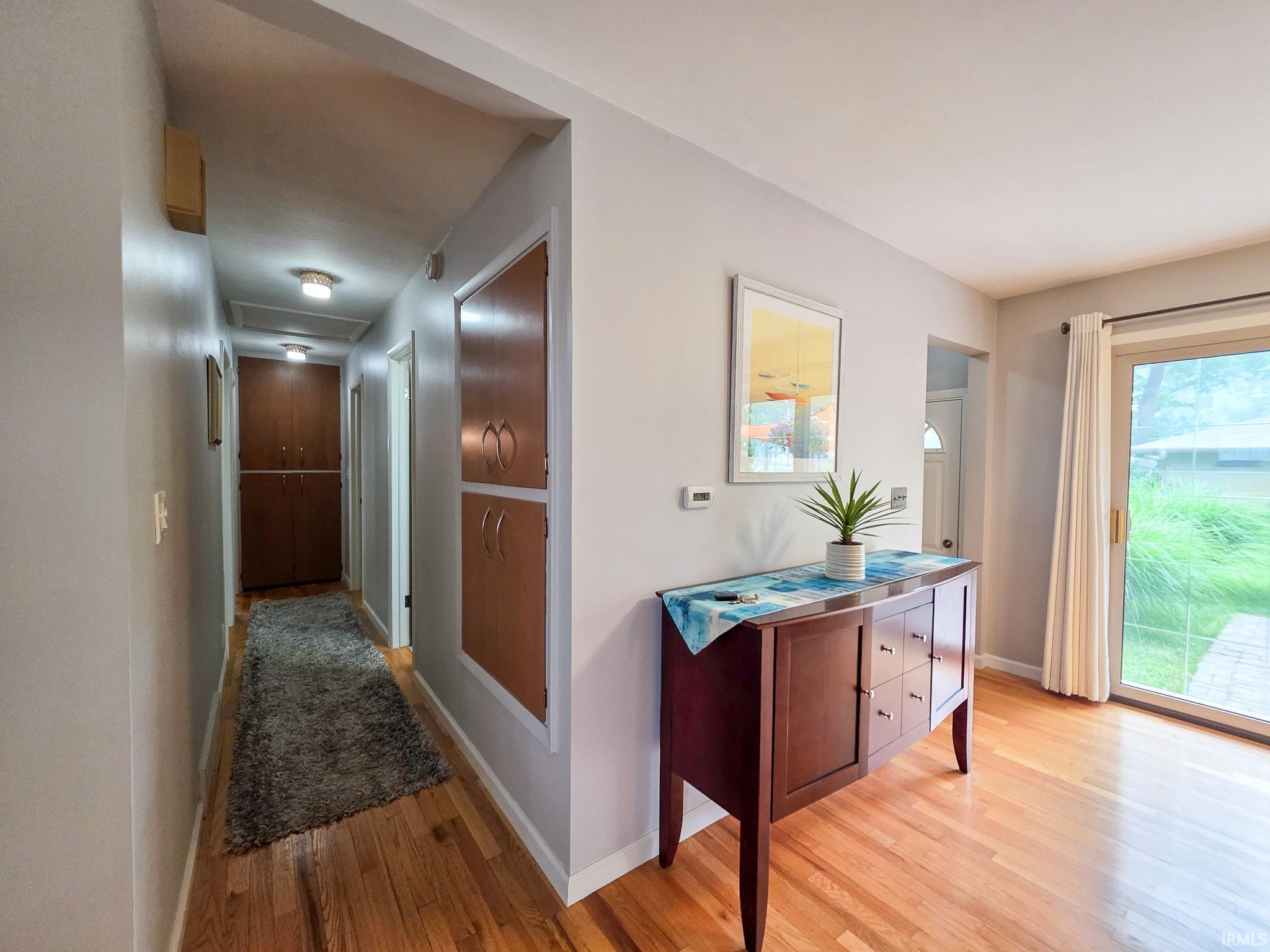 Hallway featuring wood-finish flooring and built-in cabinetry.