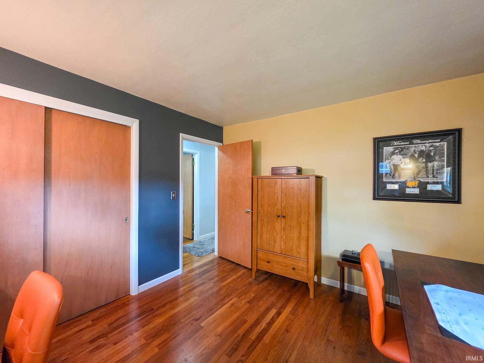 Interior space featuring wood-finish flooring, light-colored ceiling, and two-tone wall paint