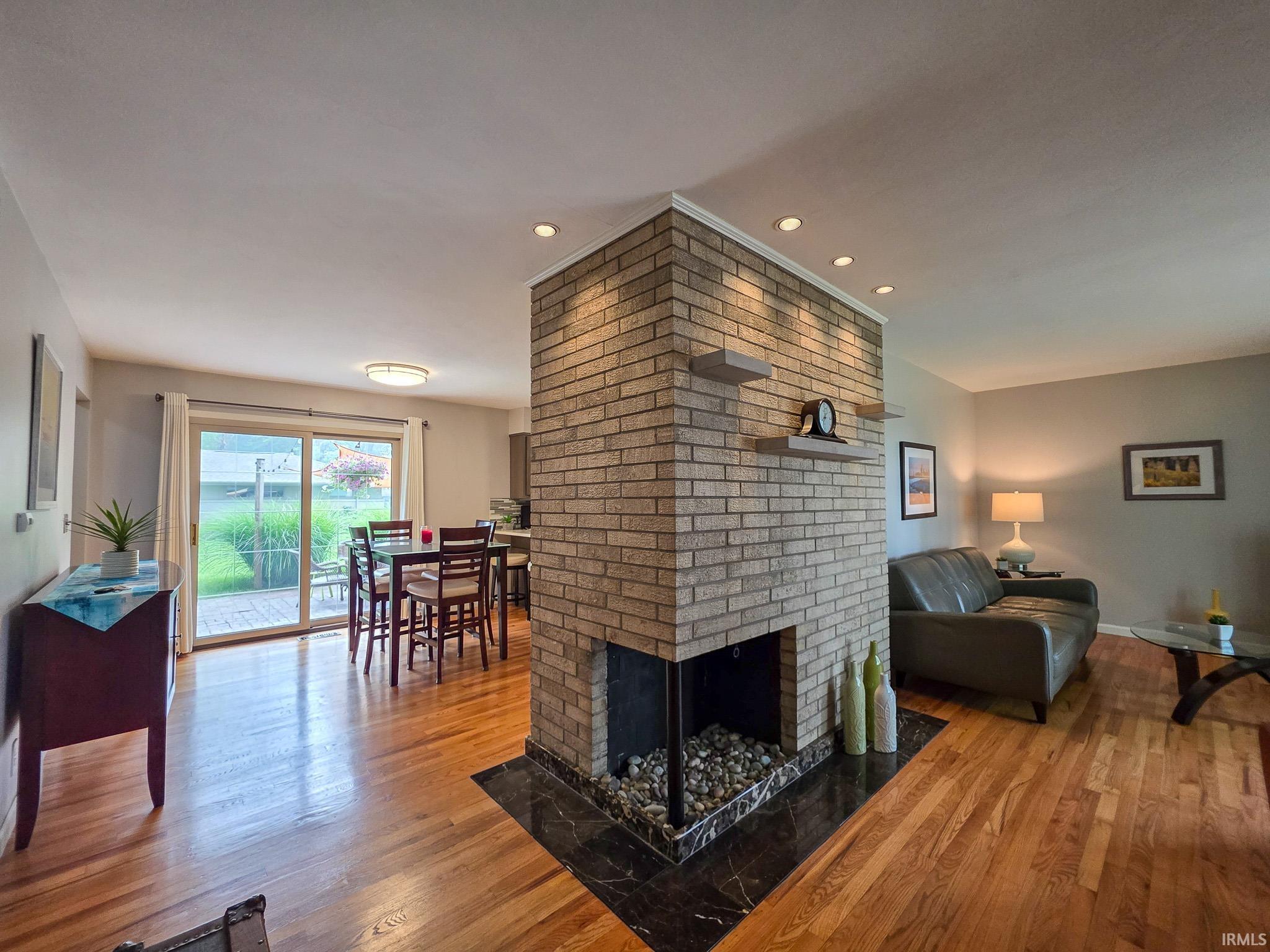 Central brick fireplace featuring a dark stone hearth and integrated shelving