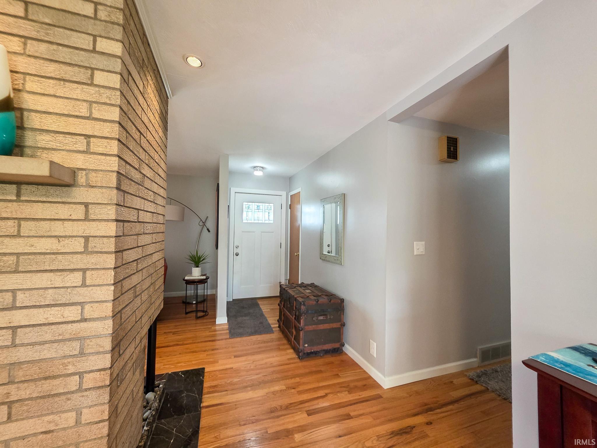 Warm wood-finish flooring complements the light gray wall tones and white trim