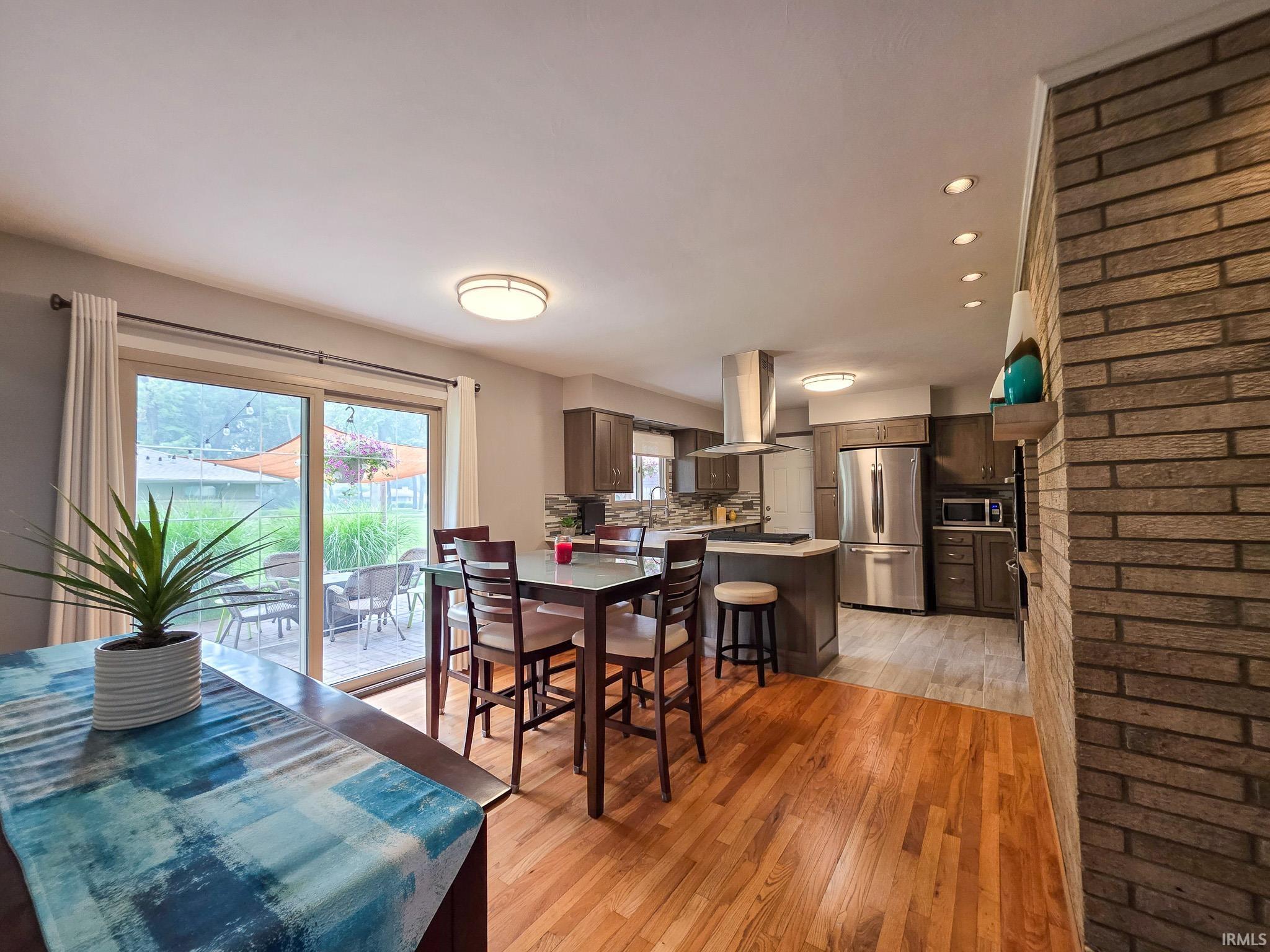 Open-concept dining and kitchen space featuring hardwood-finish flooring and recessed ceiling lighting