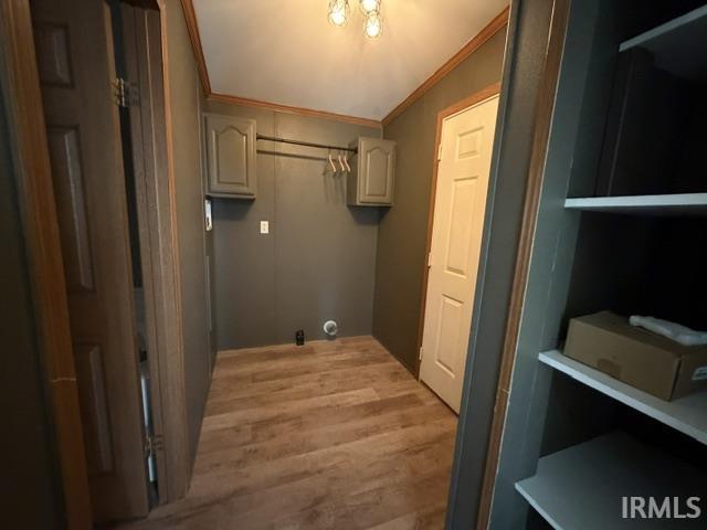 Dedicated utility space featuring wood-finish flooring and a neutral color palette