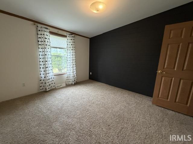 Room featuring beige carpeting and a single window with a white frame