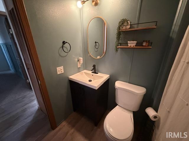 Bathroom featuring a contemporary vanity with an integrated sink, matte black faucet, and oval mirror