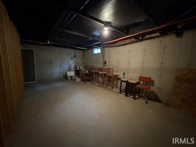 Unfinished basement with concrete flooring and exposed concrete walls