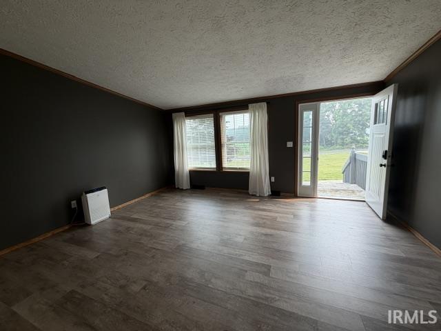 Spacious room featuring wood-finish flooring, dark accent walls, and white trim