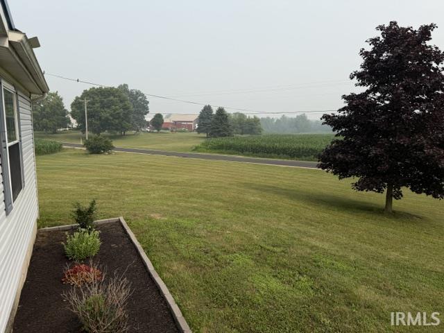 Expansive green lawn with mature trees and a dedicated landscape bed