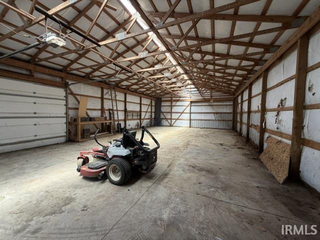 Spacious pole barn with exposed wood beam construction and concrete flooring