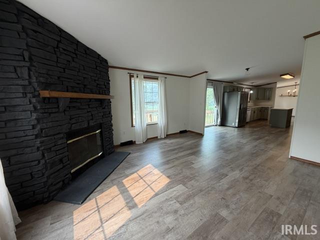 Spacious living area featuring a dark stone-clad fireplace with a wood mantel