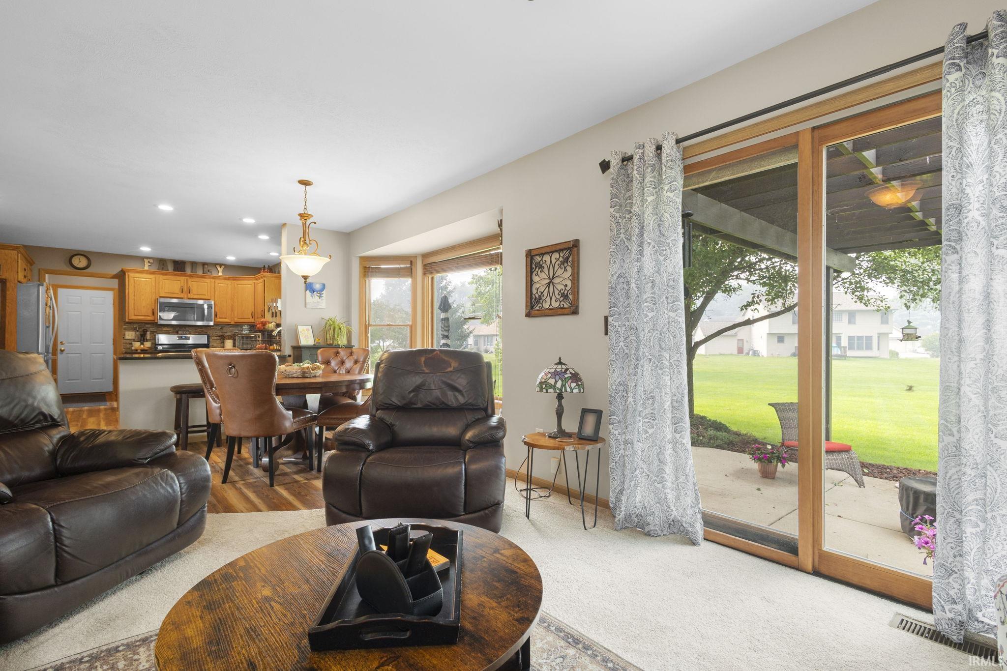 Living area featuring sliding glass doors, bay windows, and carpeted flooring