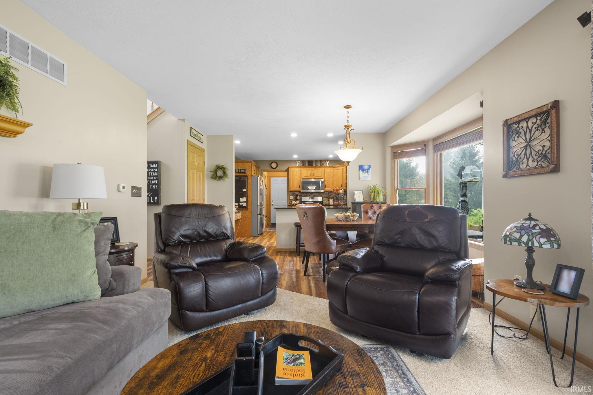 Living area featuring a bay window, recessed lighting, and a neutral color palette