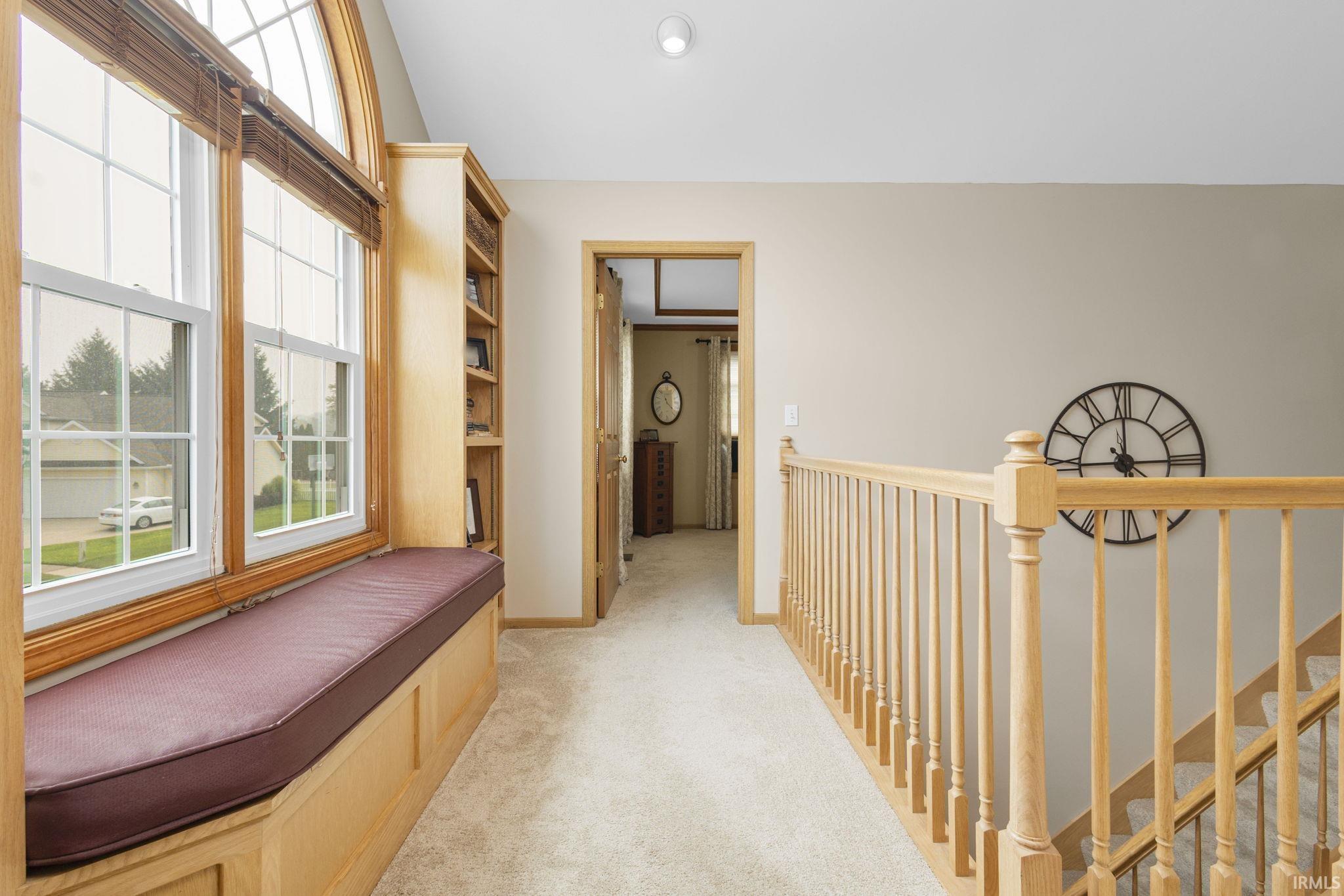 Arched window with wood trim and integrated window seat, featuring a built-in bookshelf