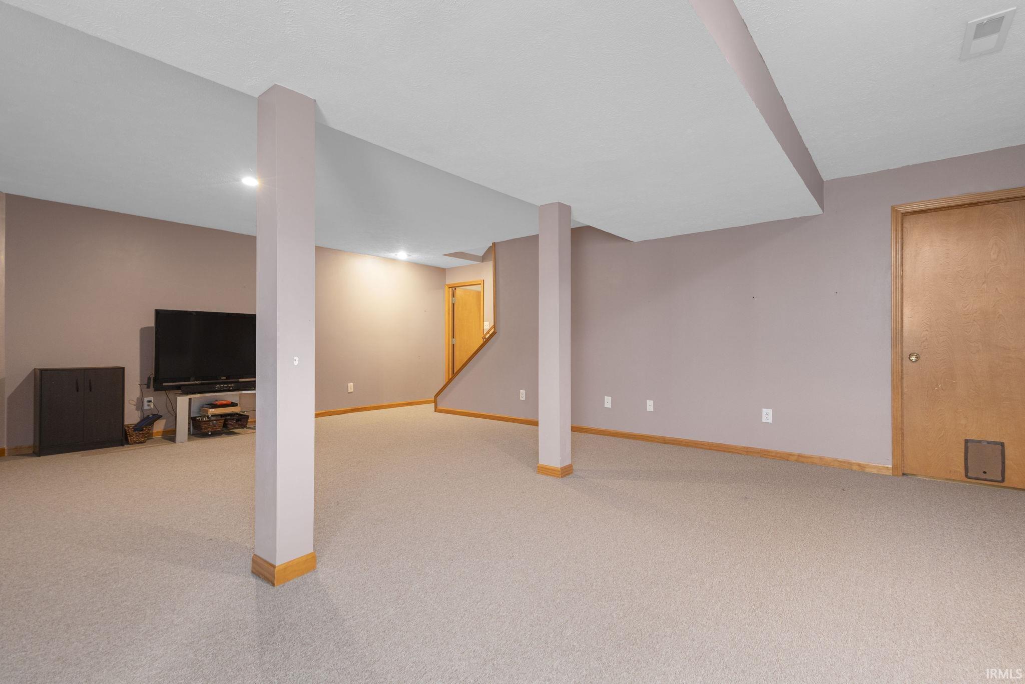 Spacious finished basement with recessed lighting, light gray carpeting, and neutral wall tones
