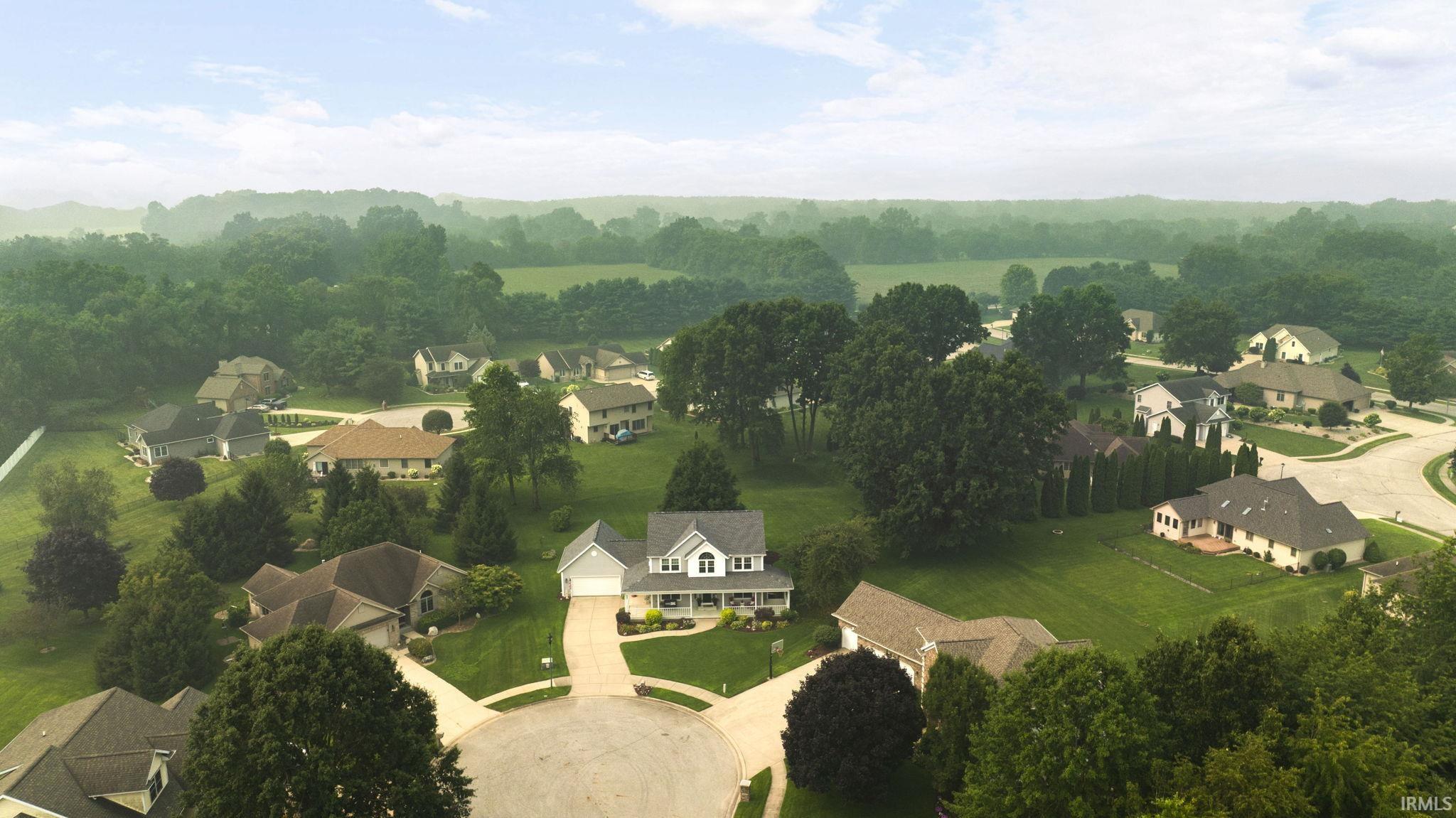 Expansive residential area featuring numerous single-family homes, mature trees, and manicured green spaces