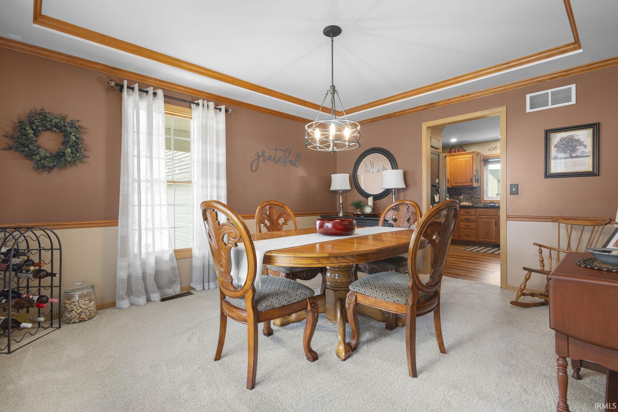 Dining area featuring light-colored carpeting and a chandelier with a metal frame