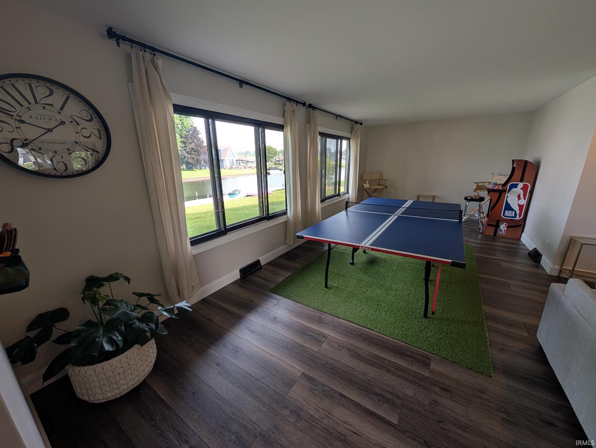 Spacious interior featuring wood-finish flooring, ample natural light through multiple windows, and baseboard trim