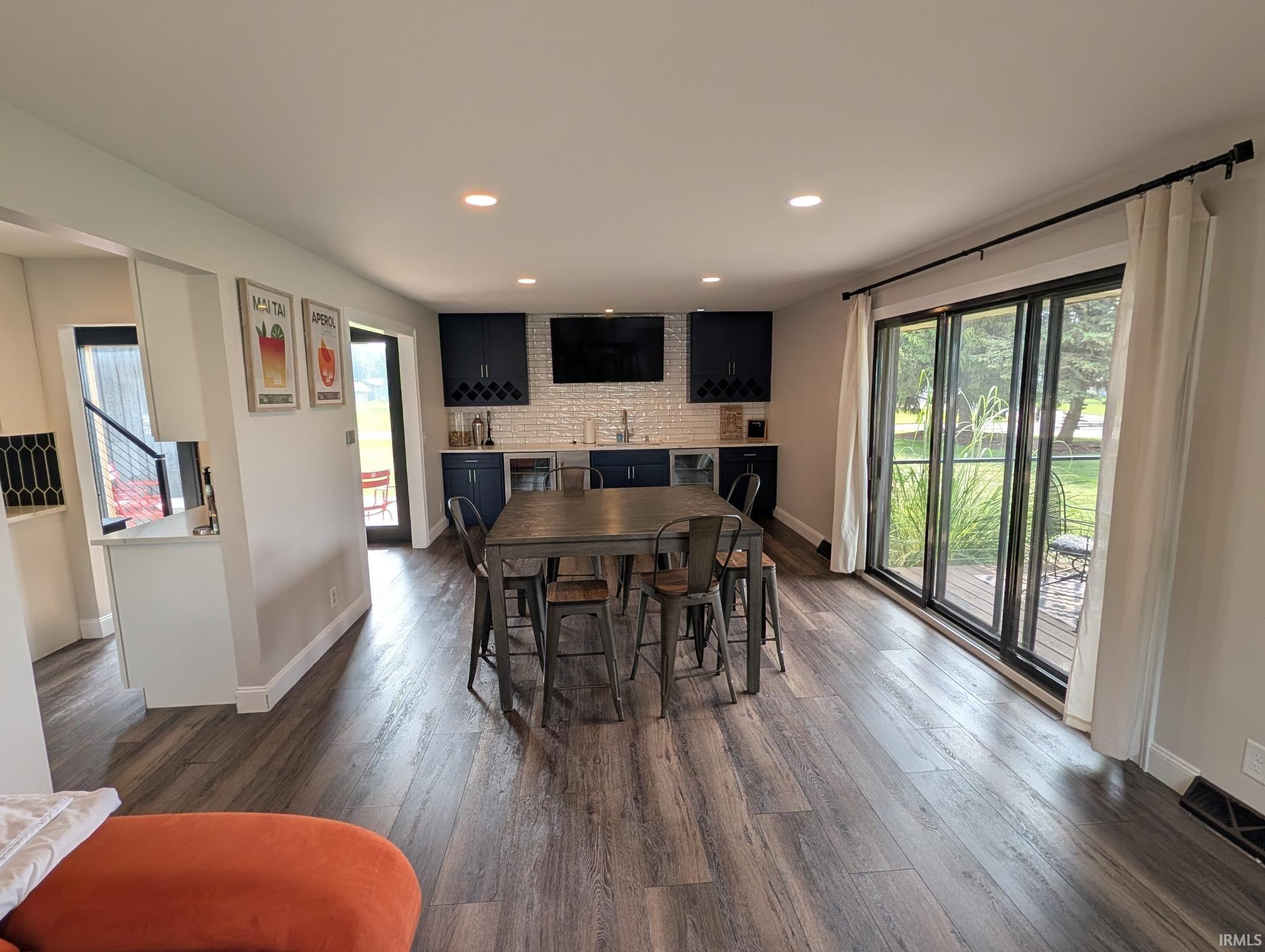 Spacious room featuring wood-finish flooring and recessed lighting