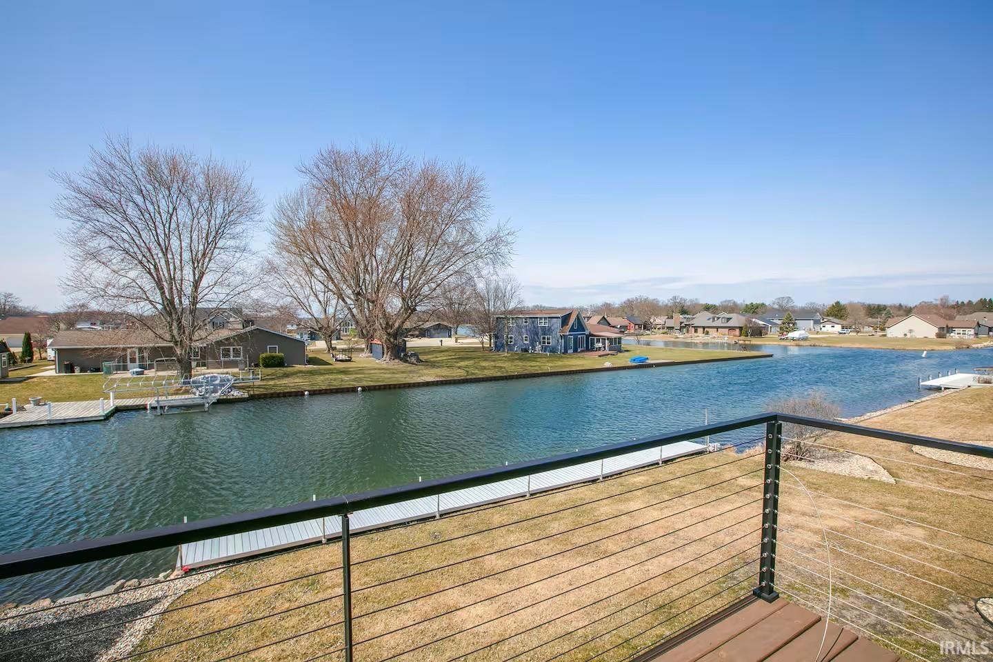 Waterfront property featuring a private dock and a cable railing deck