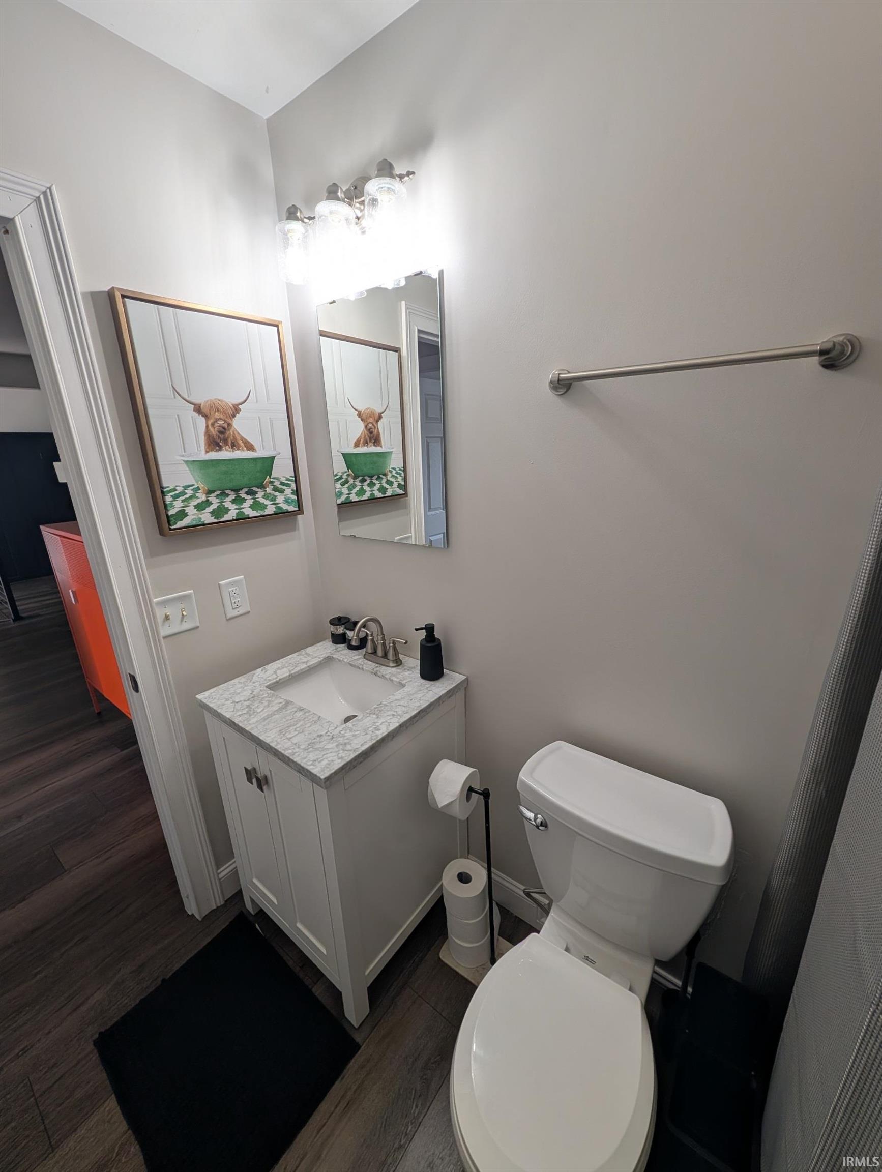 Modern bathroom featuring a white vanity with a rectangular sink and a stone-finish countertop