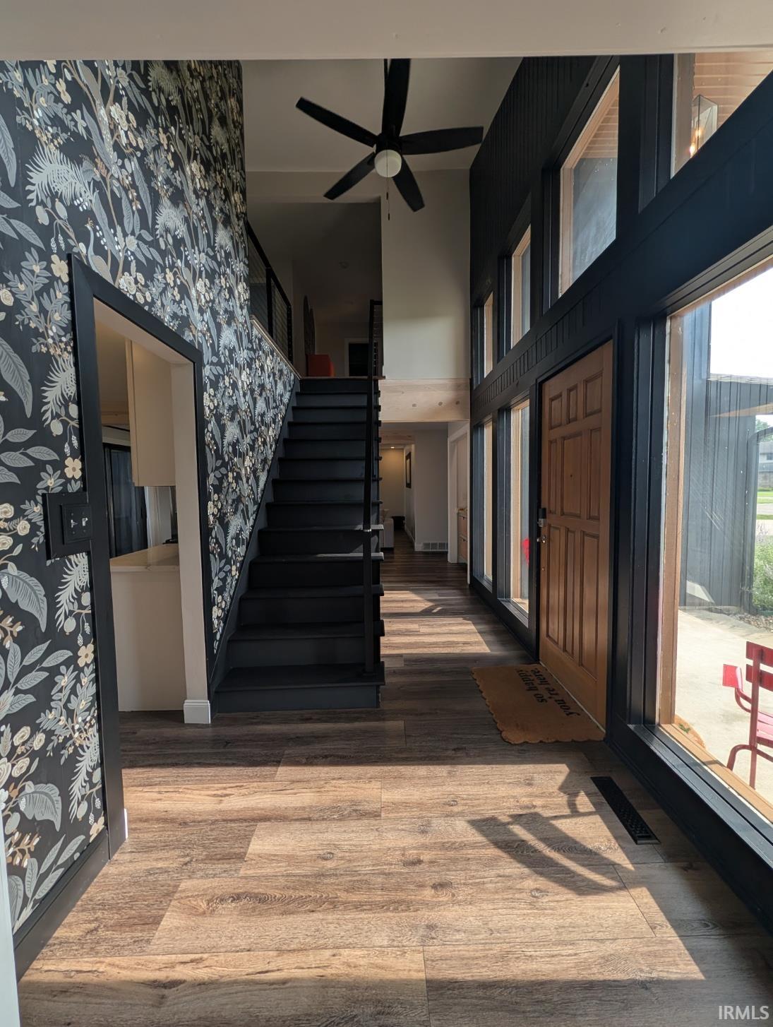 Entryway featuring wood-finish flooring and a staircase with a dark finish