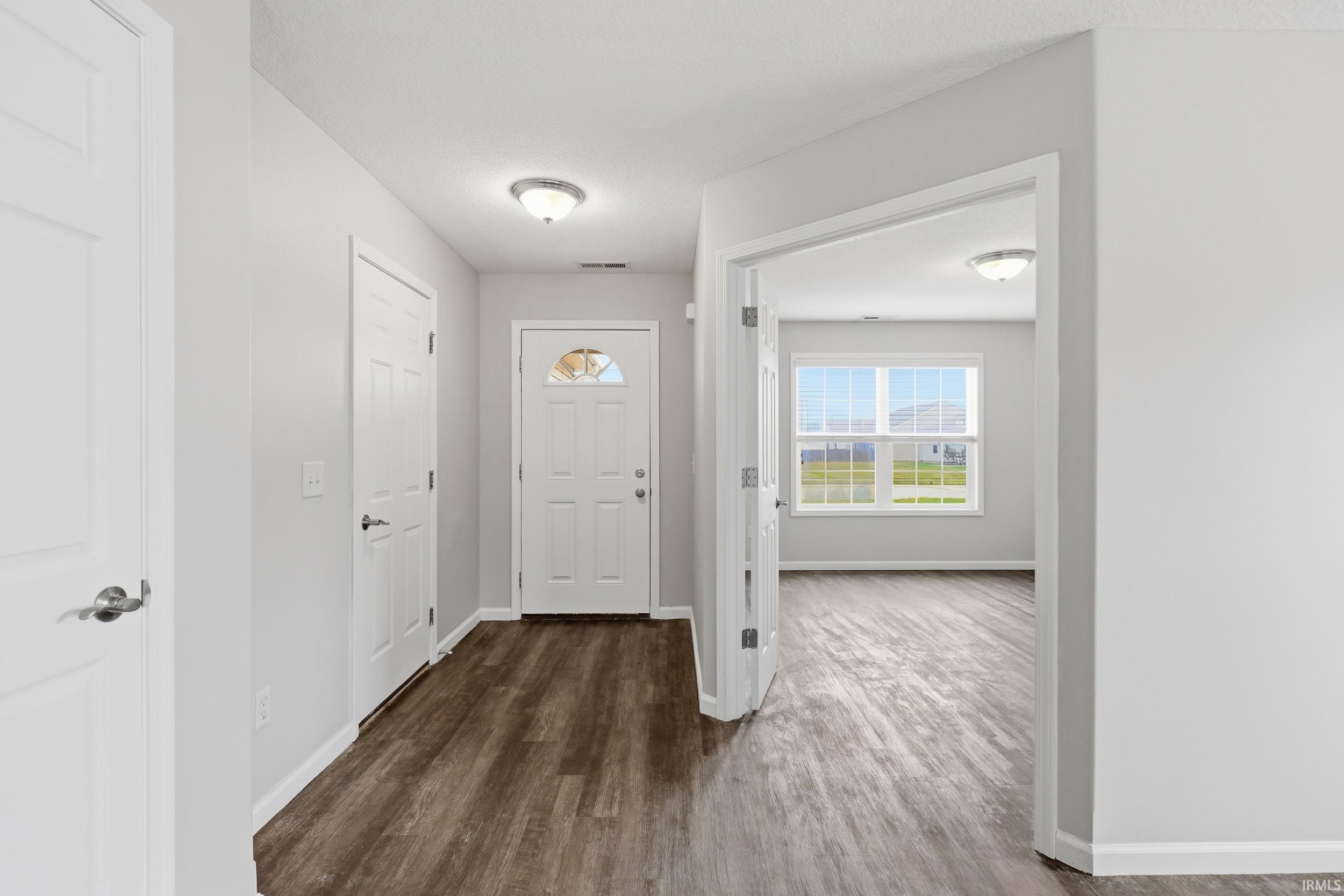 Entryway featuring wood-finish flooring, white walls, and recessed lighting
