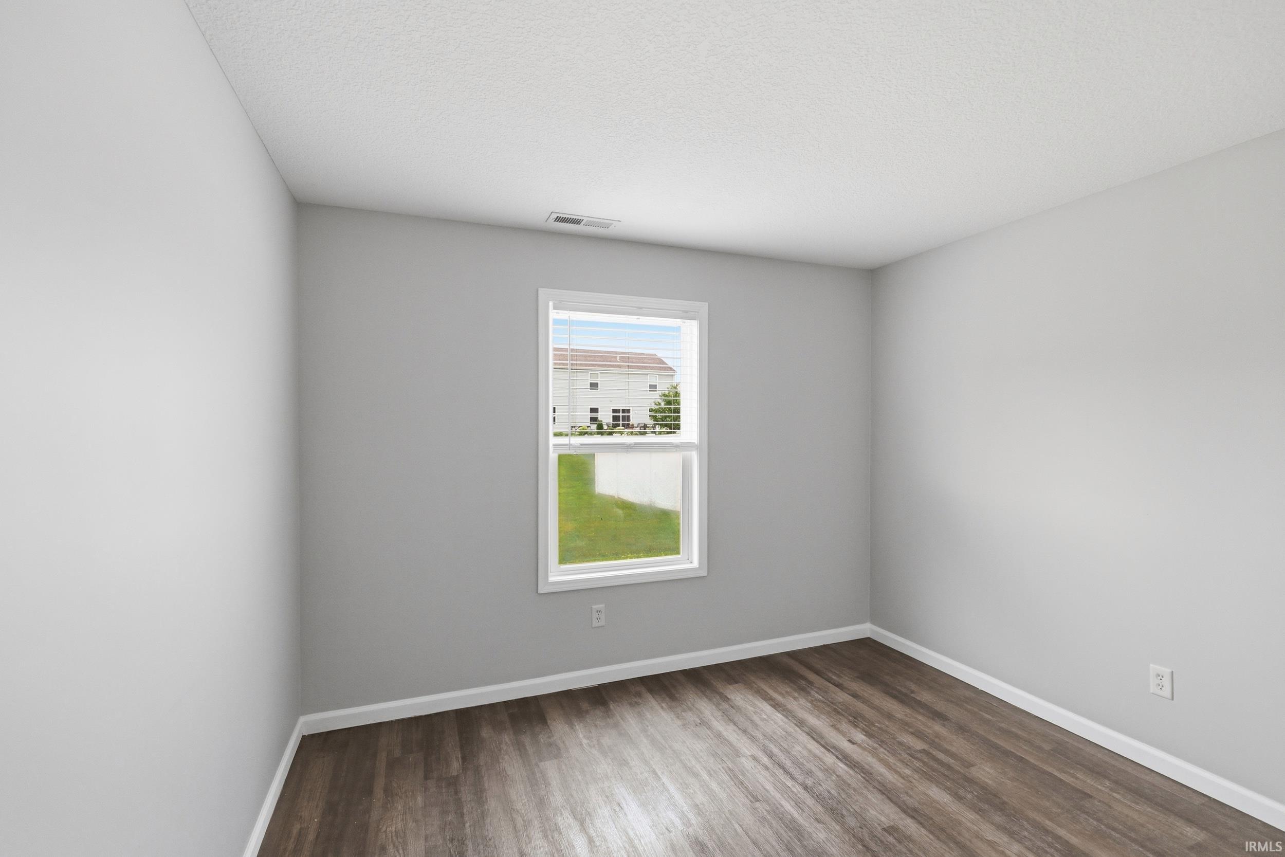 Room featuring wood-finish flooring, a double-hung window, white baseboards, and light gray painted walls