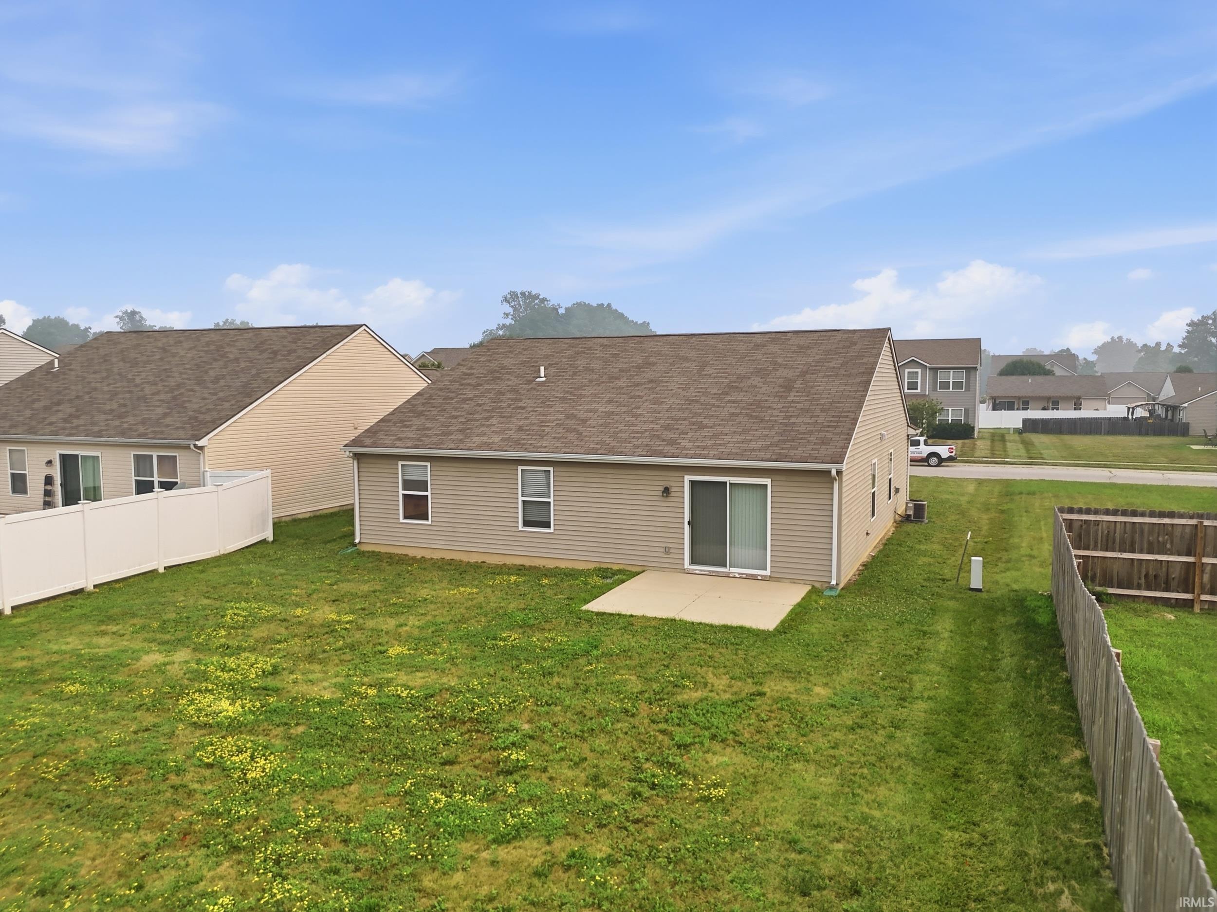 Rear exterior with tan siding and a brown shingle roof