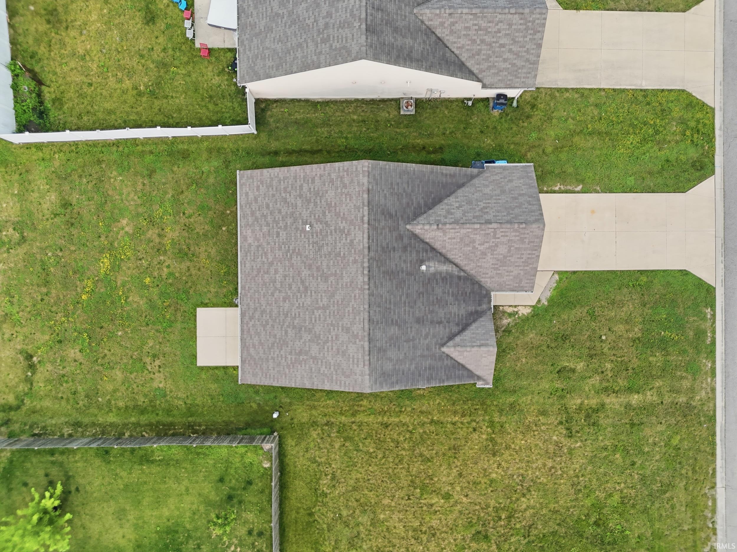 Single-family residence featuring a prominent shingle roof, concrete driveway, and a spacious green lawn
