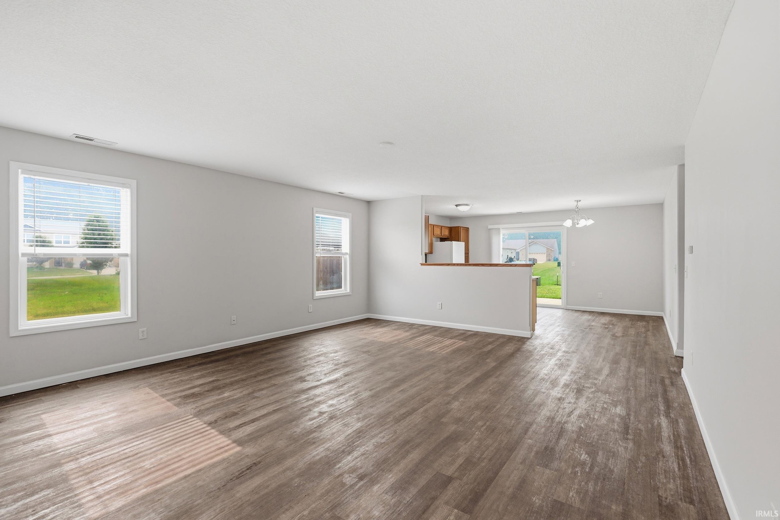 Open-concept living space featuring wood-finish flooring and neutral-toned walls