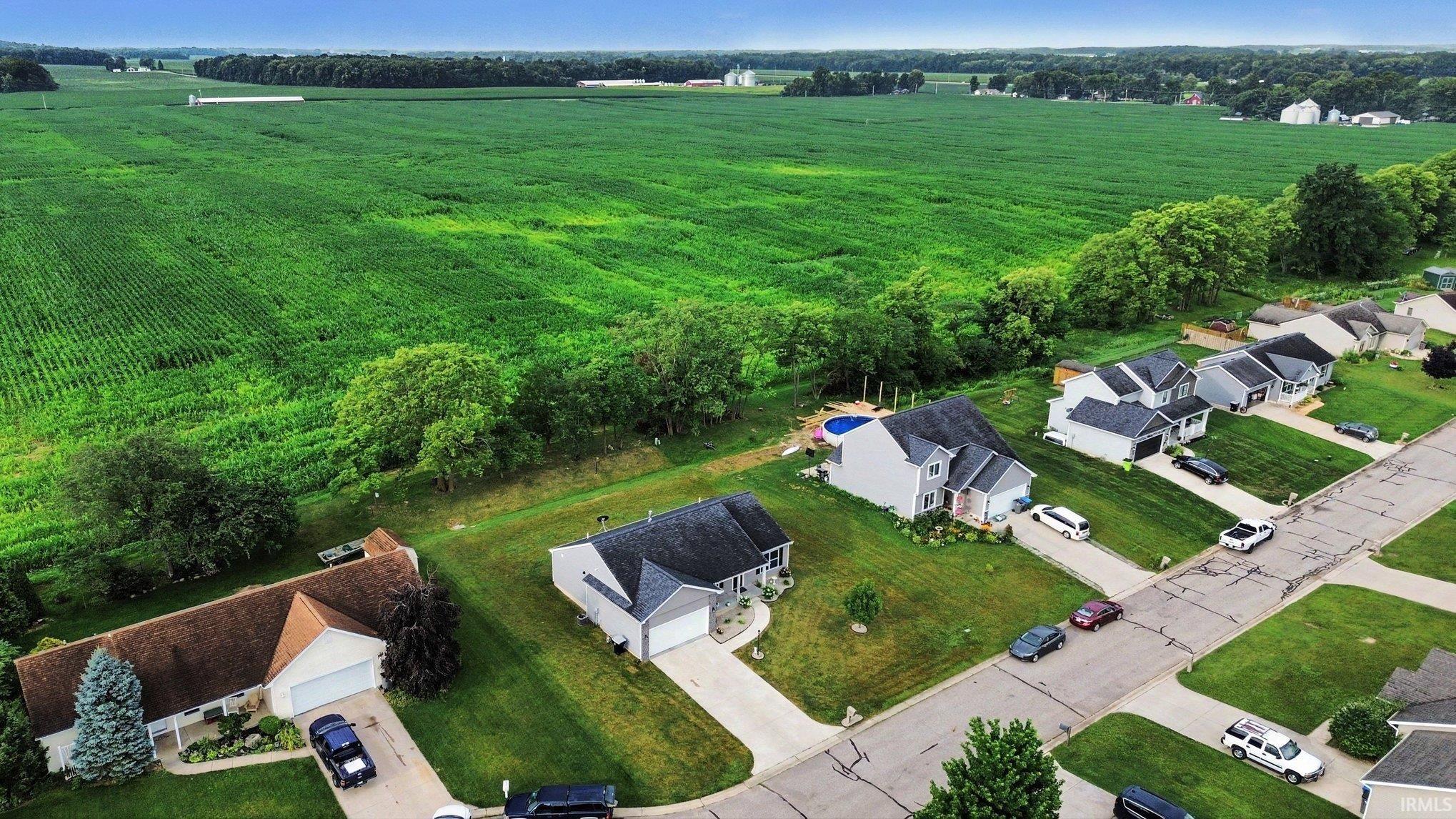 Residential properties featuring manicured lawns, paved driveways, and surrounding green spaces