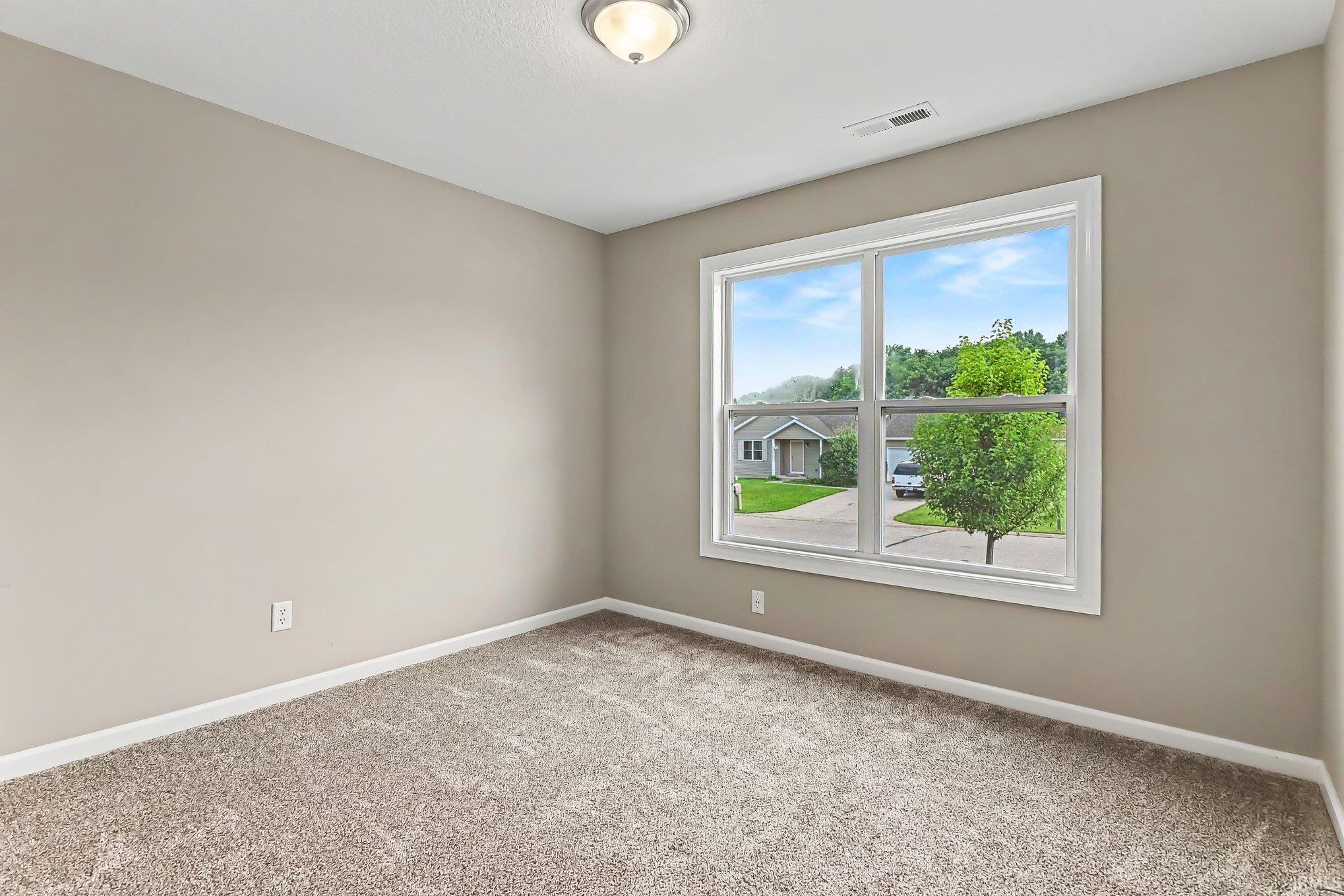 Neutral-toned walls complement plush carpeting